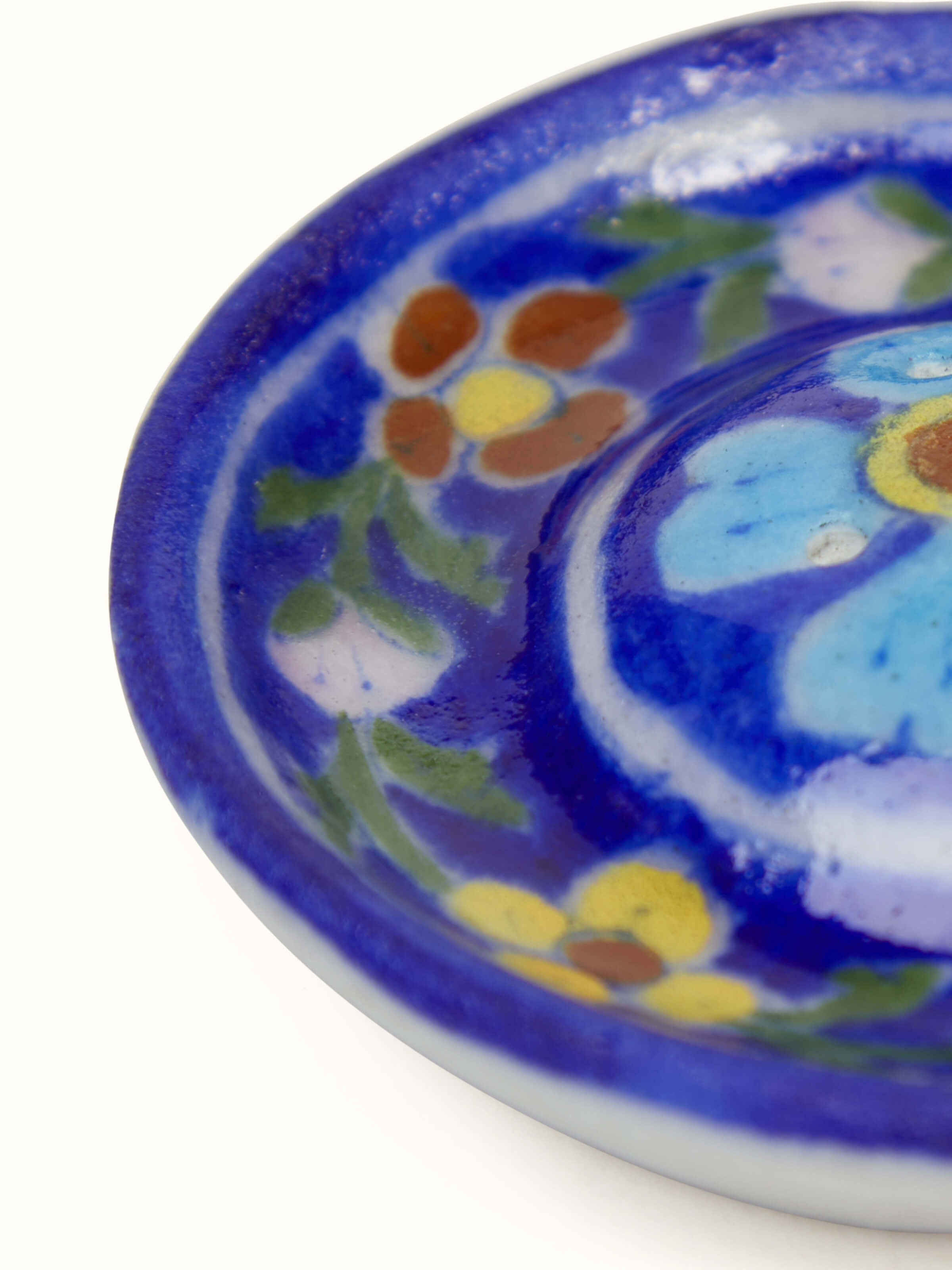 Detail shot of blue pottery ceramic floral incense stick holder showing hand painted work