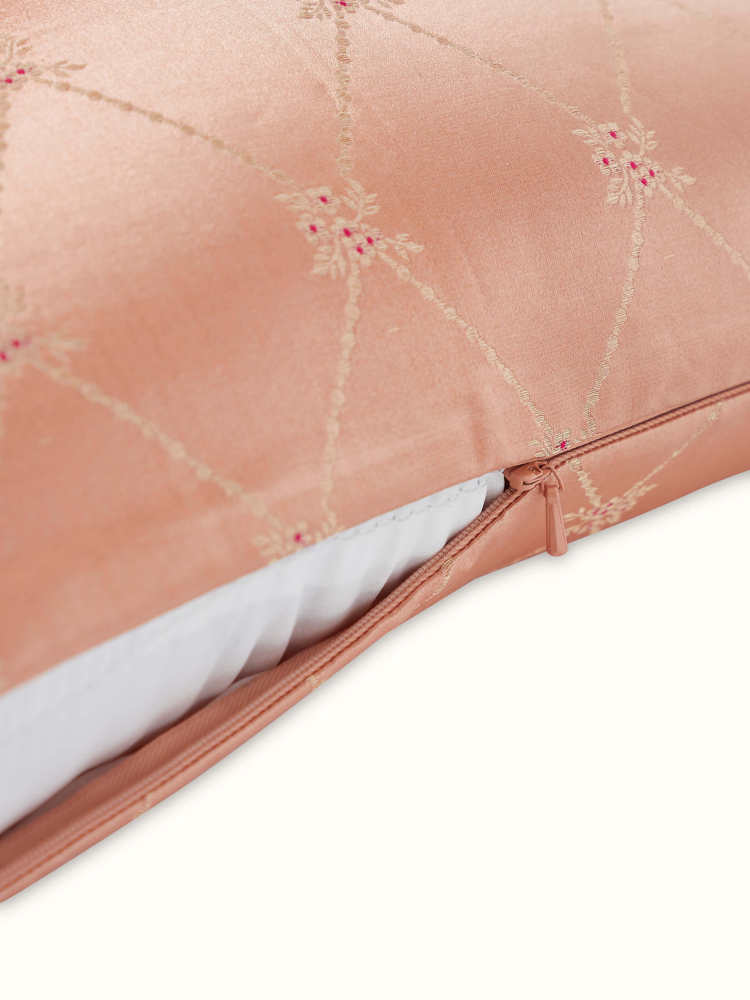 Angled view showcasing the shine and texture of peach Banarasi handloom silk cushion.