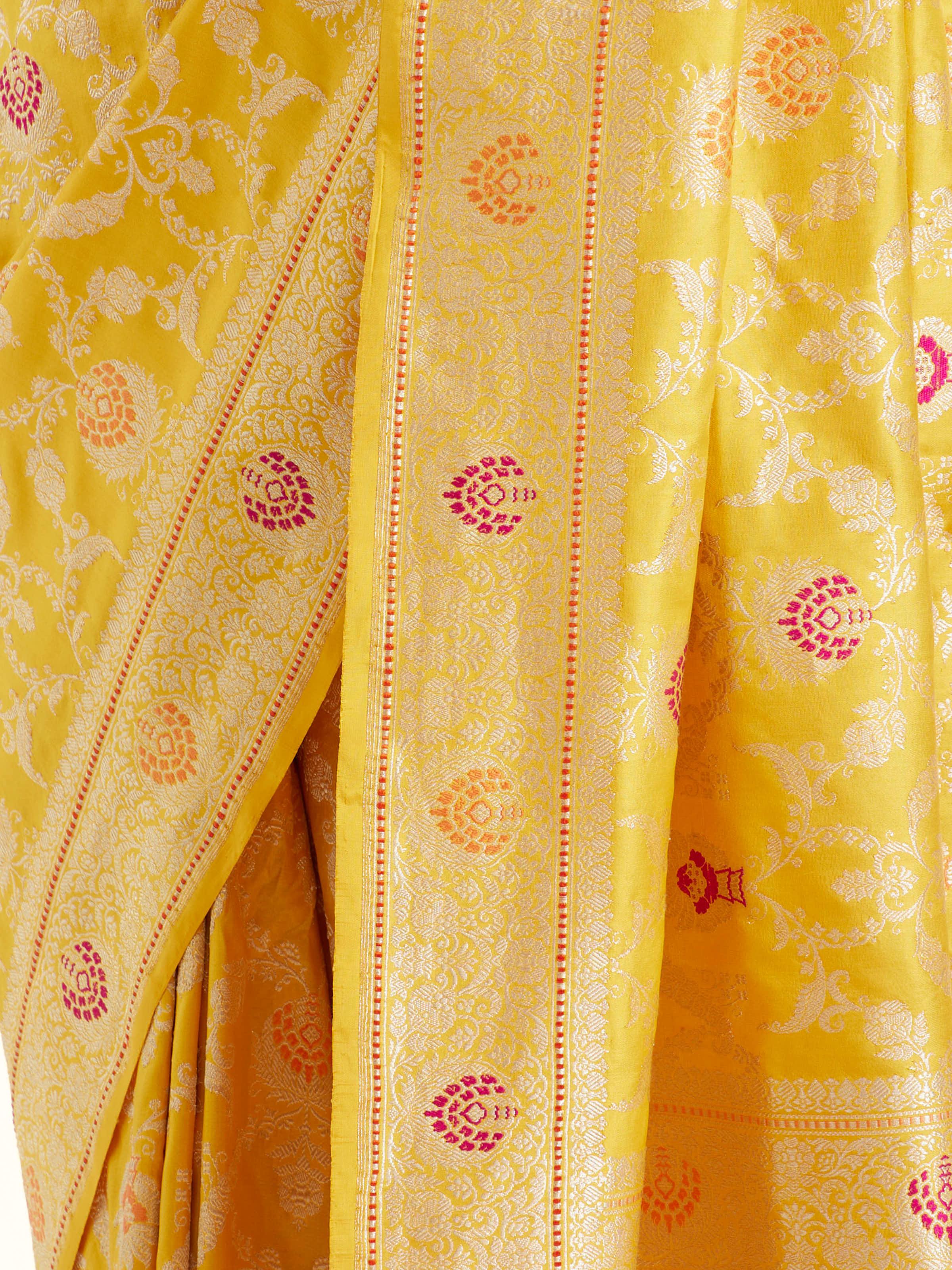 Detail view of yellow Banarasi silk kadwa jaal saree showing silk texture and zari craftsmanship