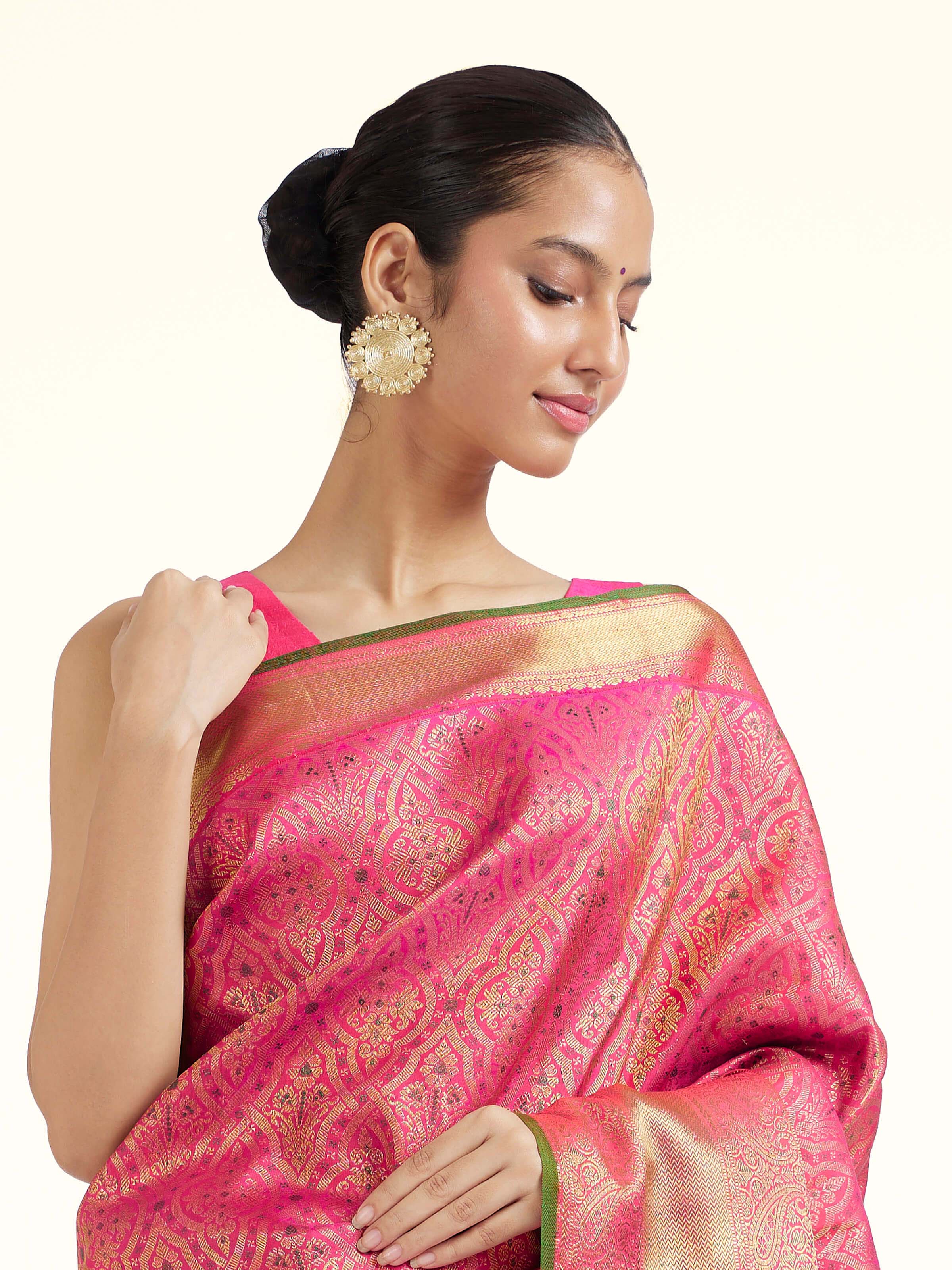 Angled view of pink silk Kancheepuram saree highlighting traditional weave and sheen