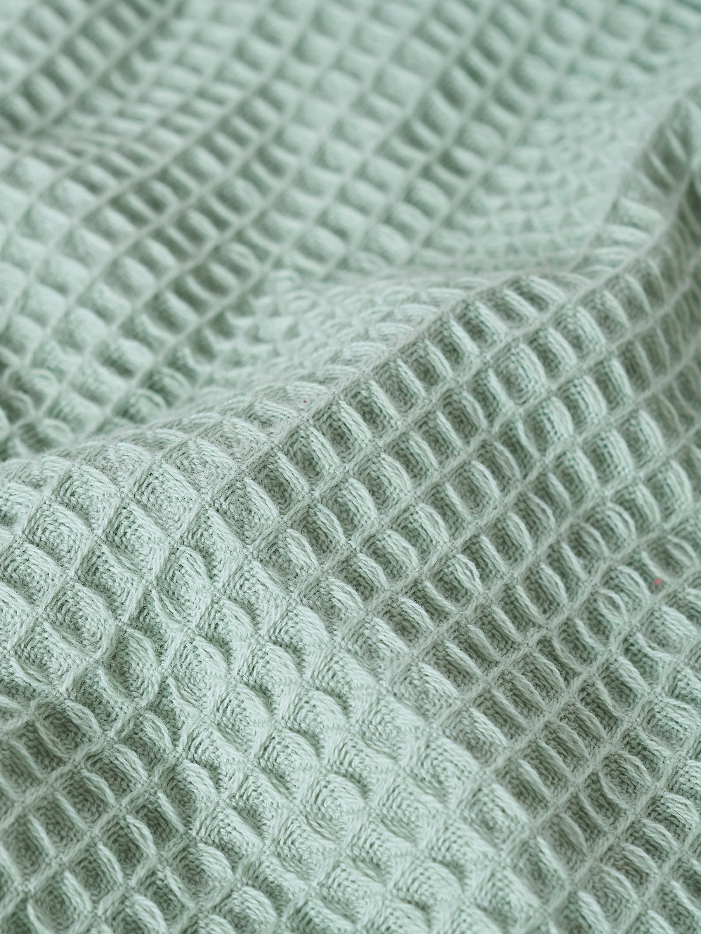 Close-up of waffle weave texture on green cotton hand towel