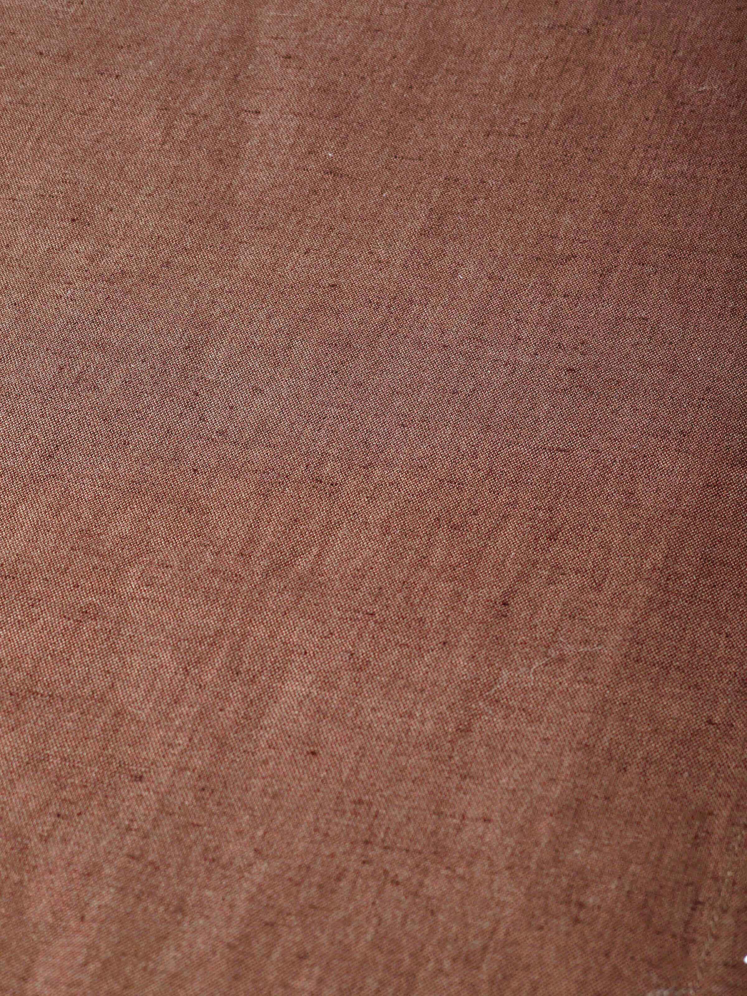 Close-up of hand embroidery and stitched border on brown table mat