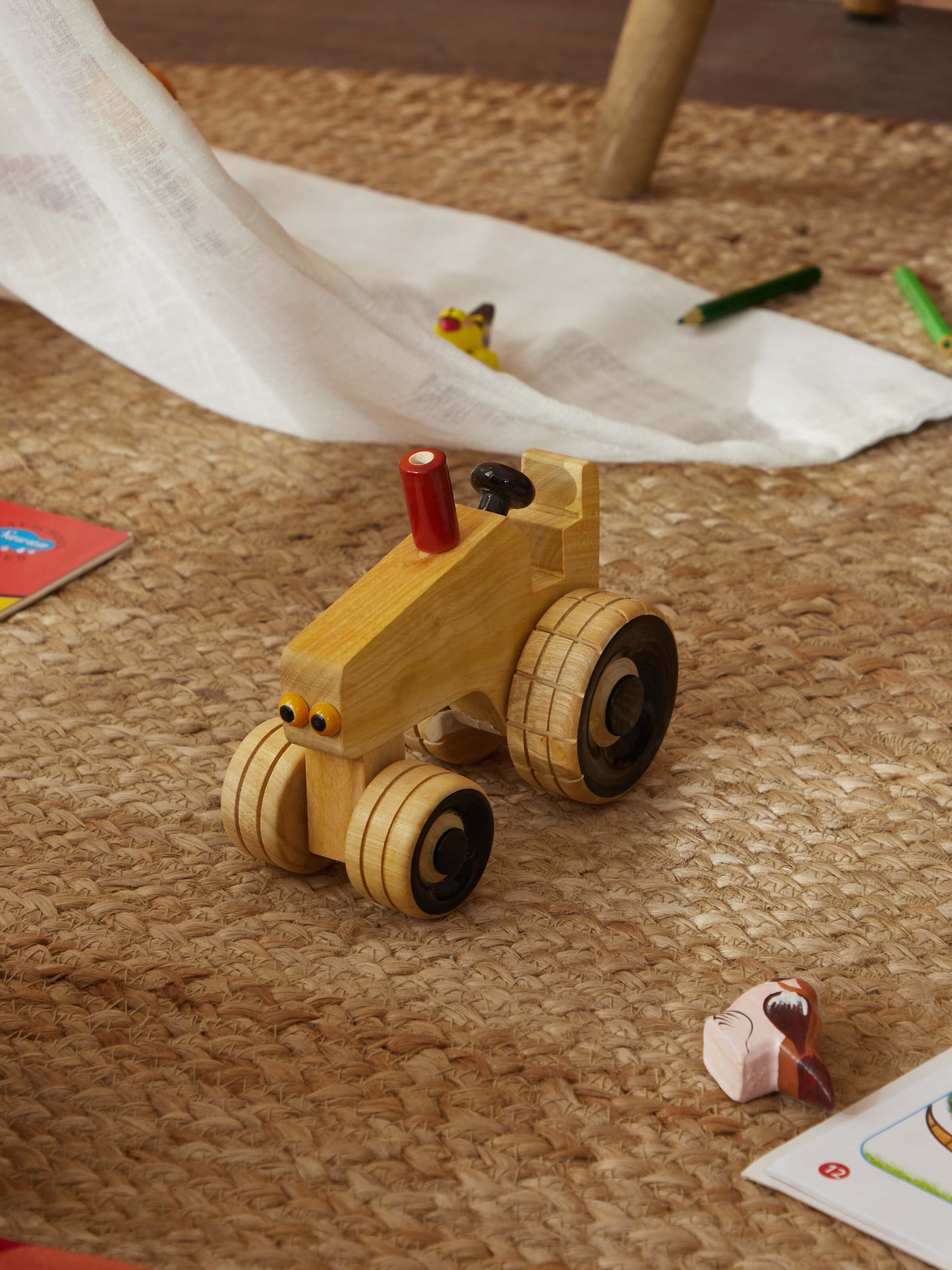 Side view of white Channapatna ivory wood tractor toy showcasing fine craftsmanship