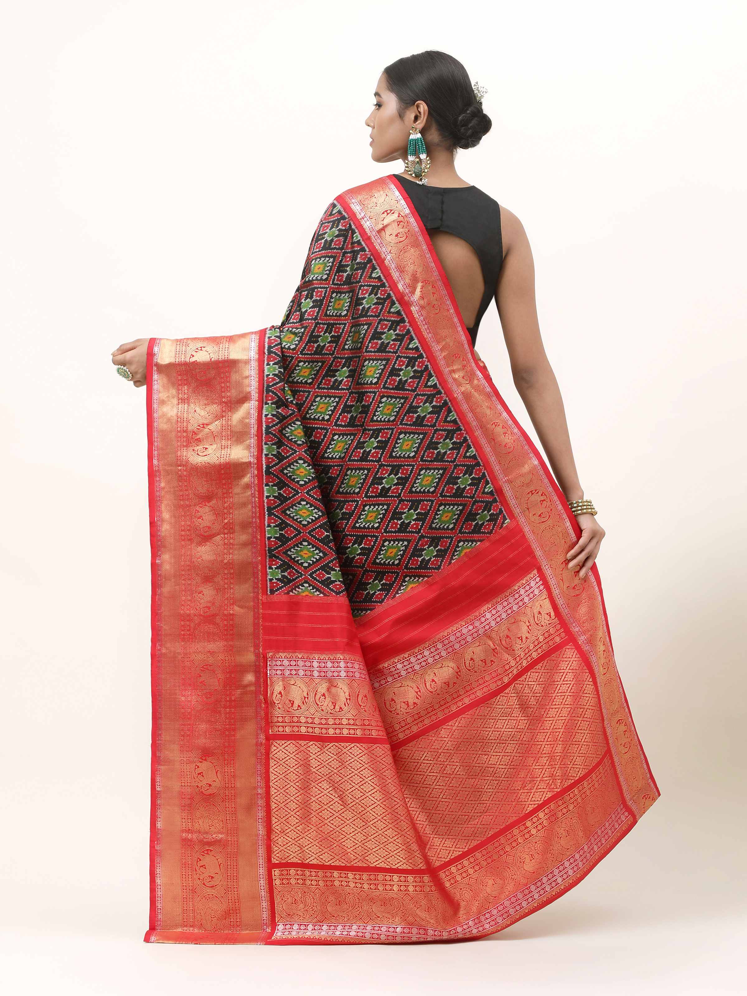 Back view of blue silk Ikat saree highlighting patterned pallu and elegant pleats.
