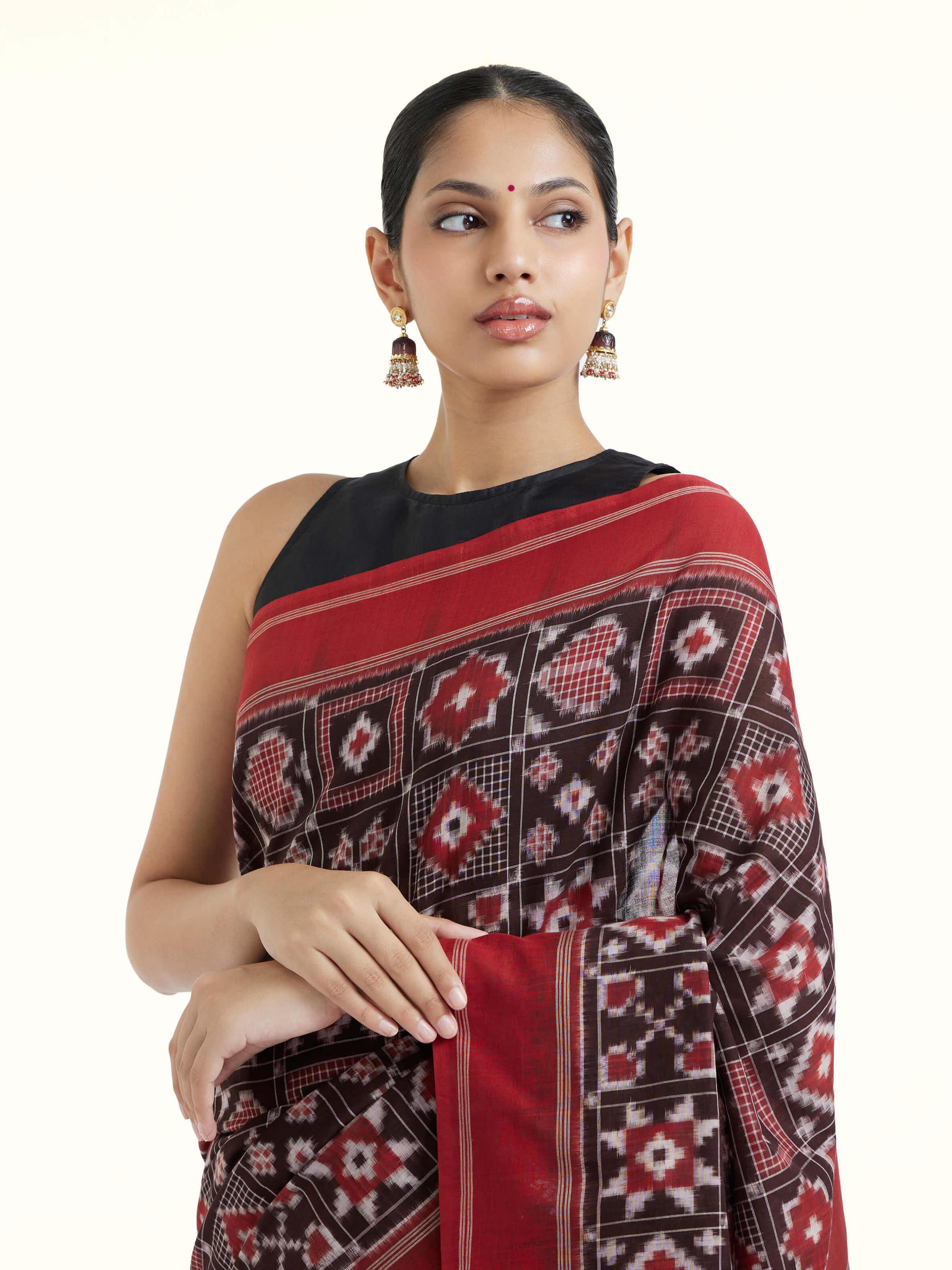 Angled view of madder red cotton double ikat saree emphasizing double ikat weave