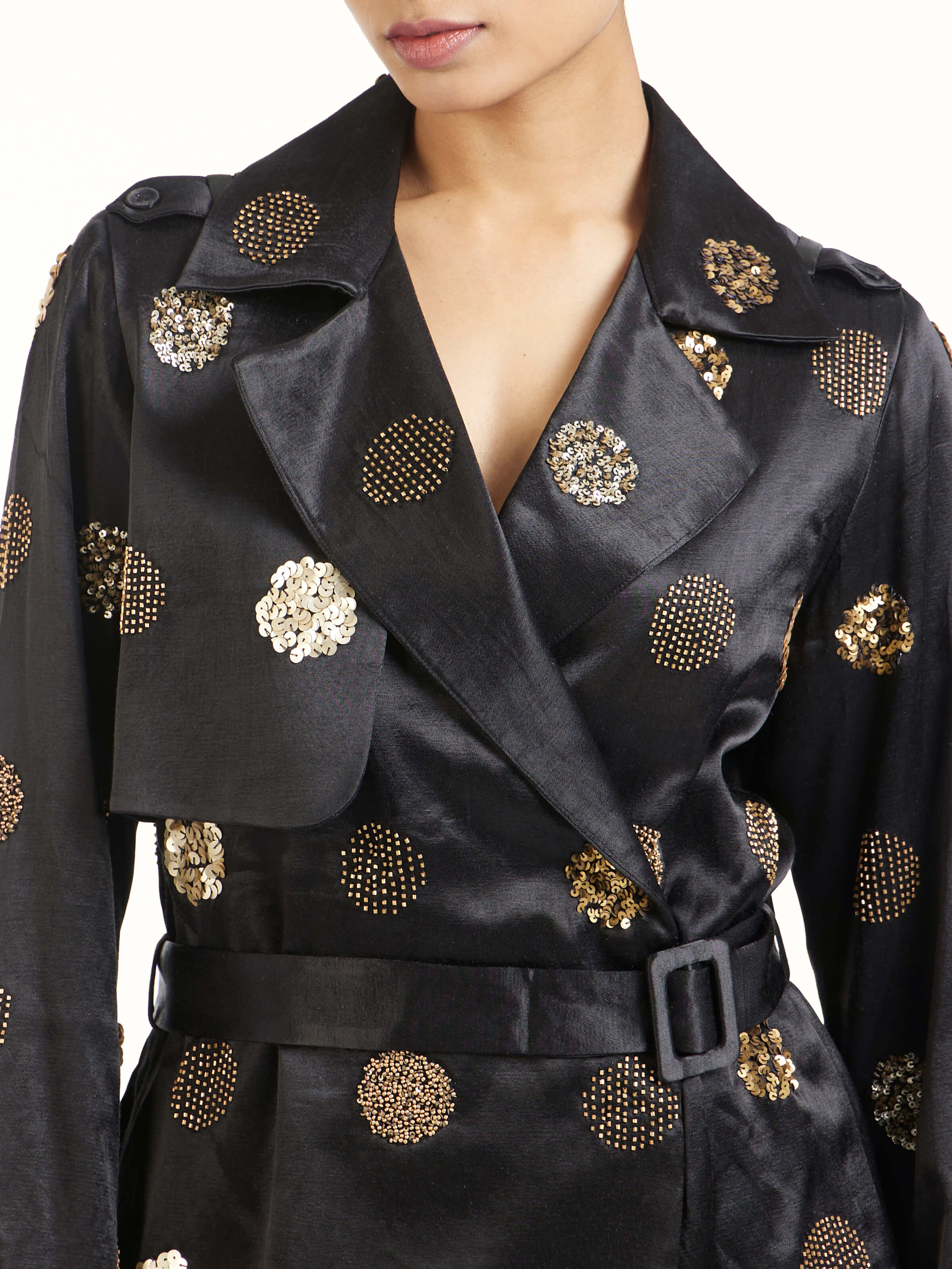 Detail view of black hand embroidered dotted gold jacket showing craftsmanship