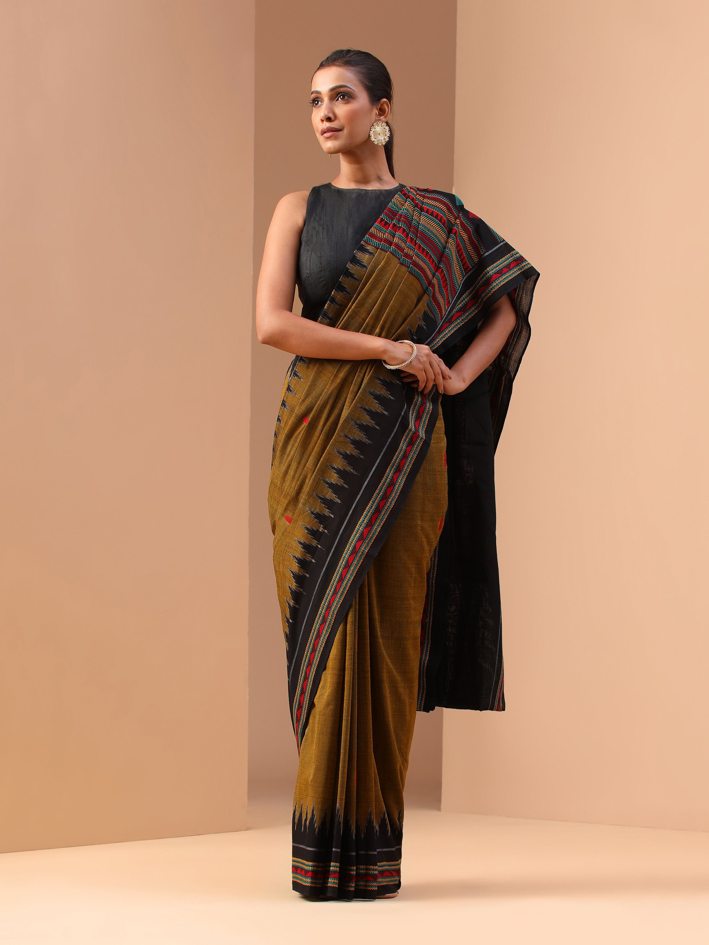 Lifestyle view of yellow Dongaria saree styled with jewelry and showcasing vibrant patterns