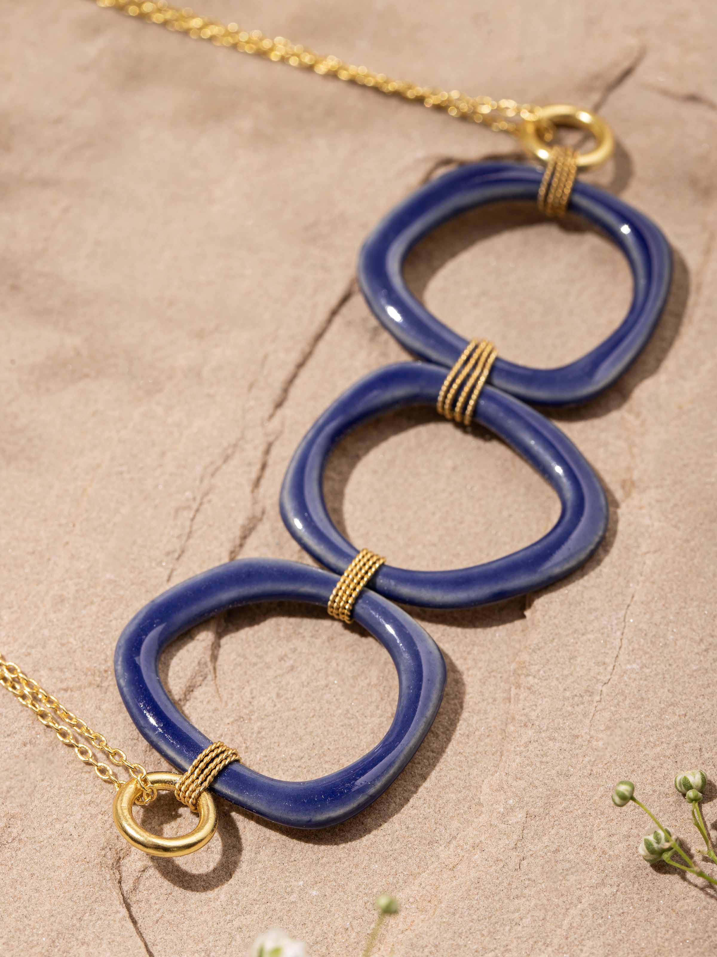 Overhead view of ceramic long necklace displaying its full length and symmetrical design