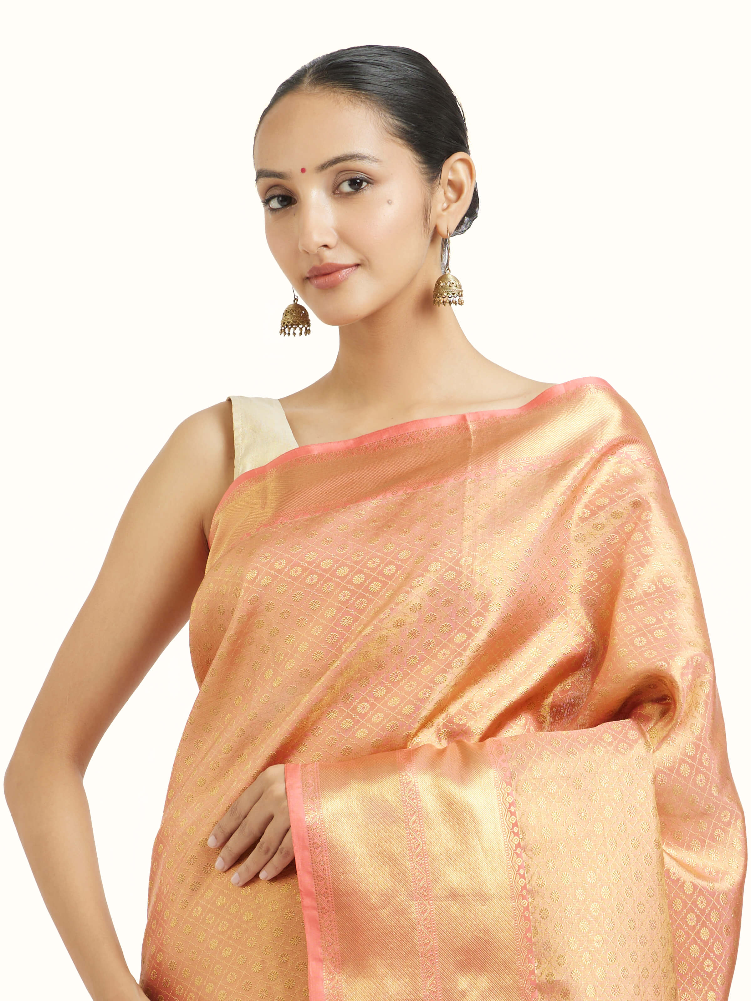 Angled view of peach silk Kancheepuram saree highlighting woven motifs