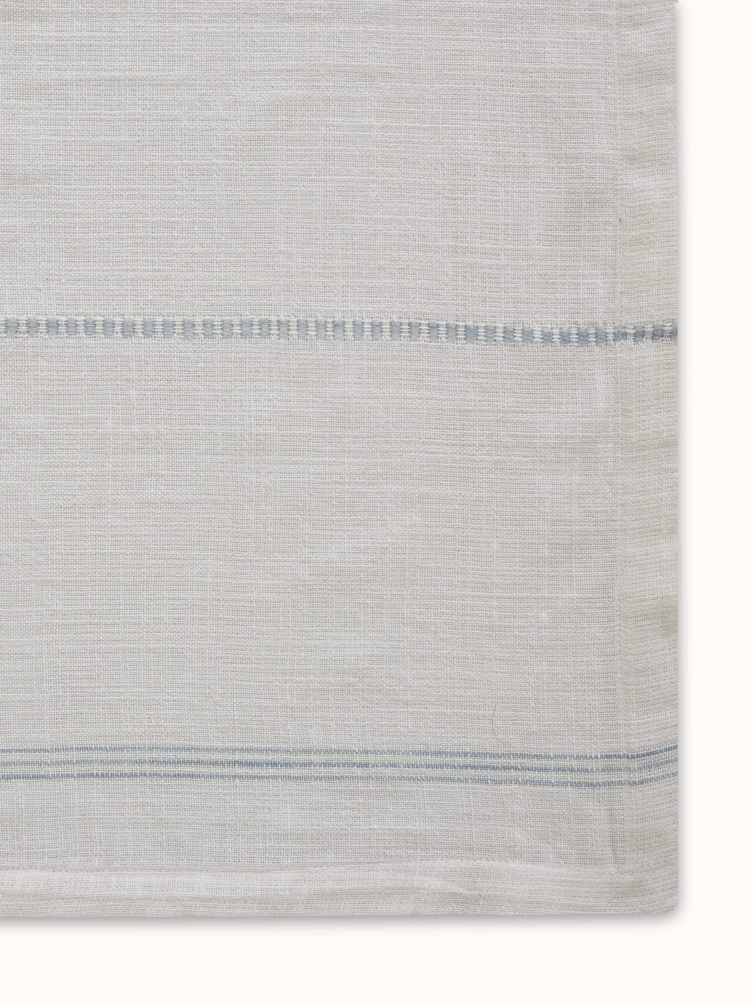 Angled view of Arth light blue stripe cotton handloom table cover highlighting fabric texture and woven stripe detail.