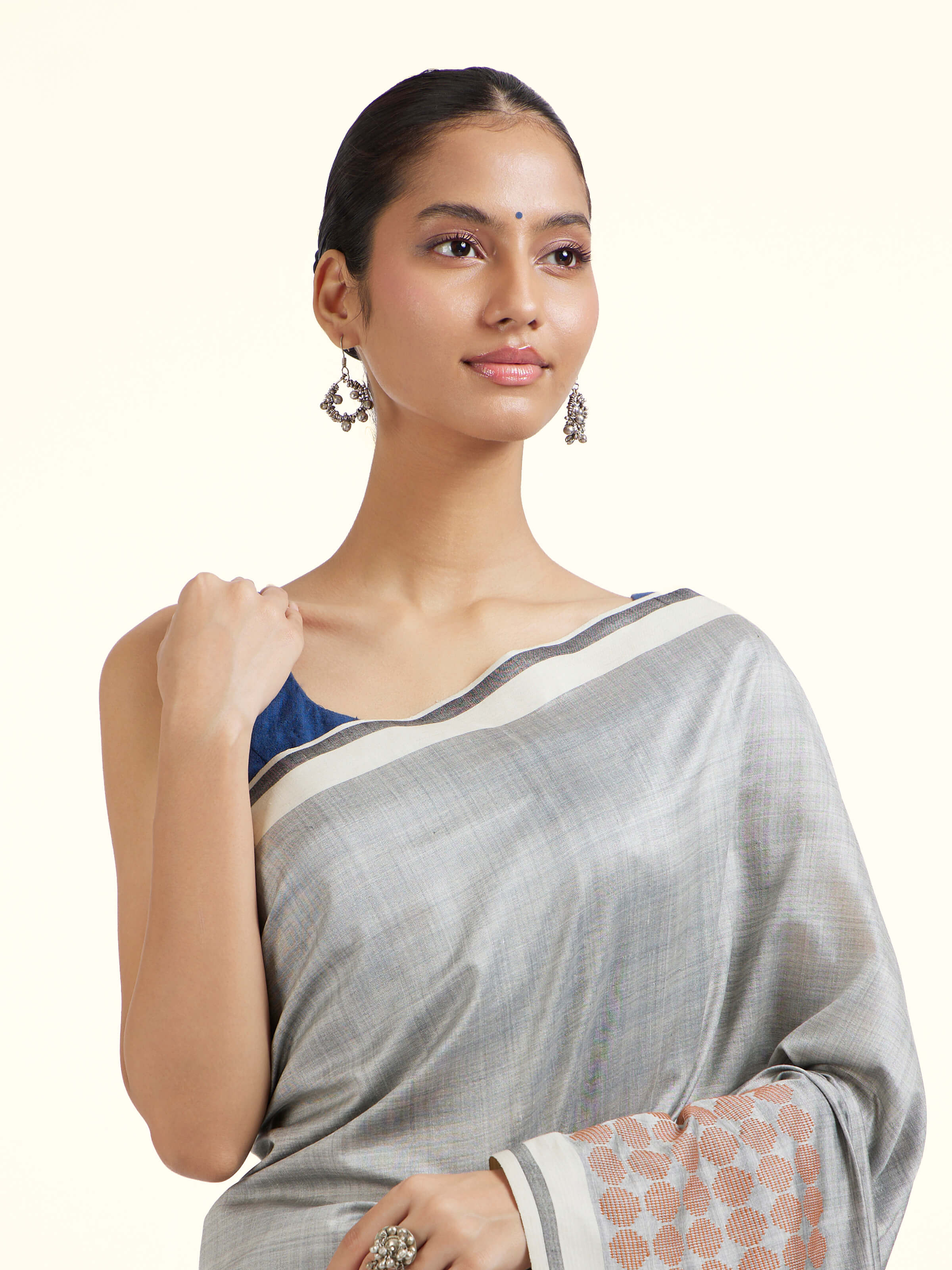 Angled view of grey silk extra-weft saree emphasizing extra-weft detailing