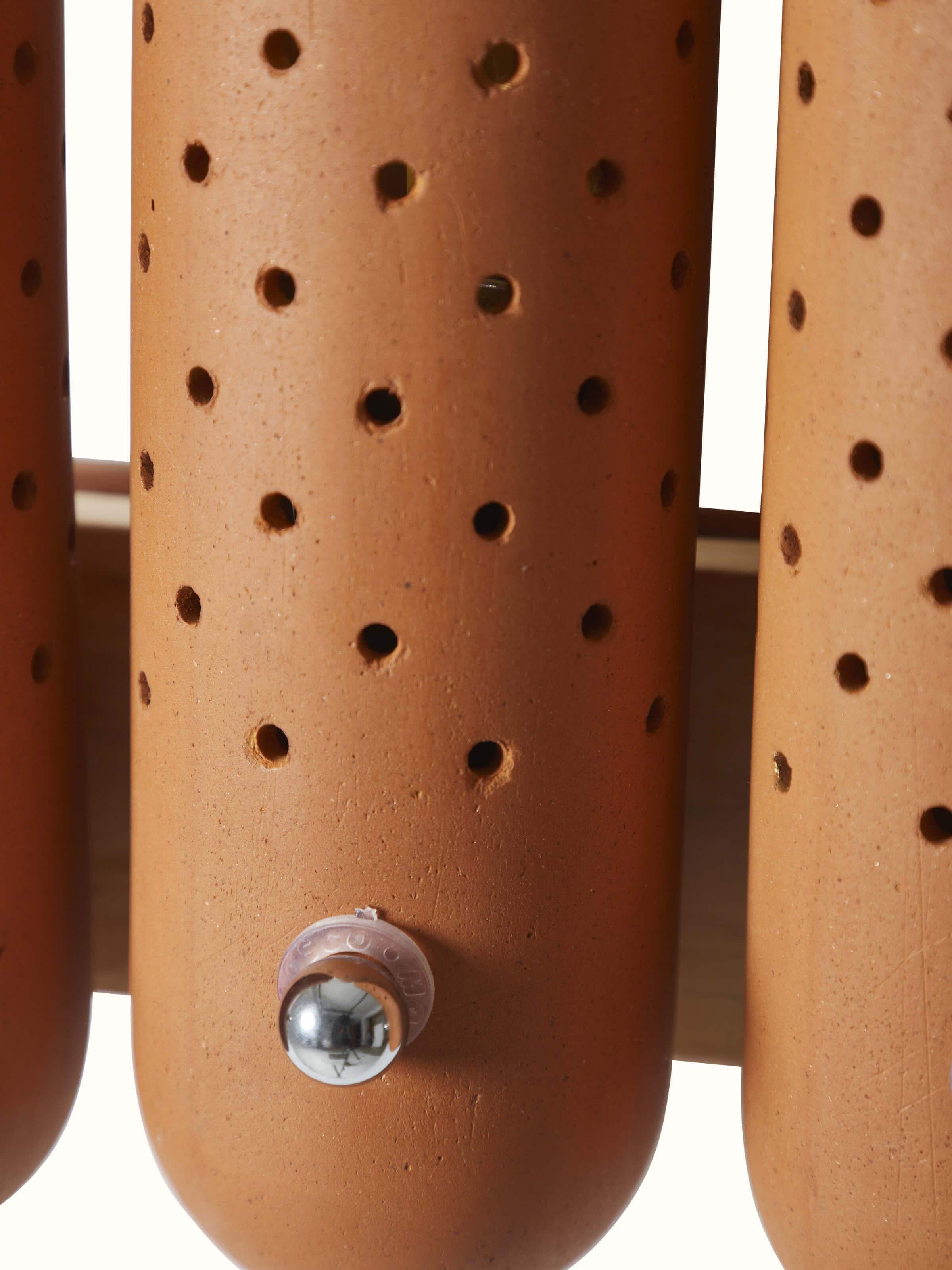 Close-up view of natural terracotta wall light, highlighting the fine details and artisanal craftsmanship.