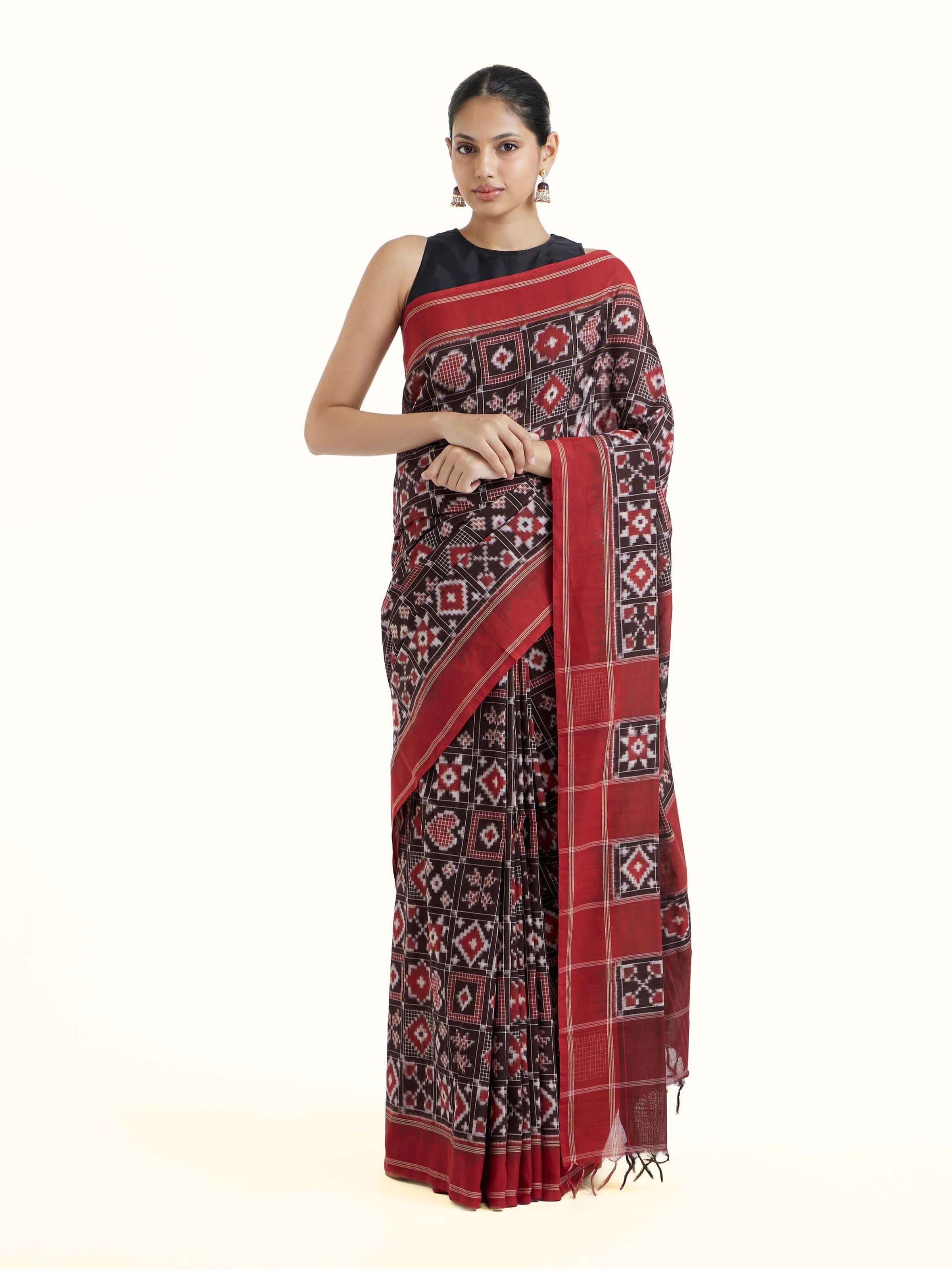 Front view of madder red cotton double ikat saree showcasing traditional geometric patterns