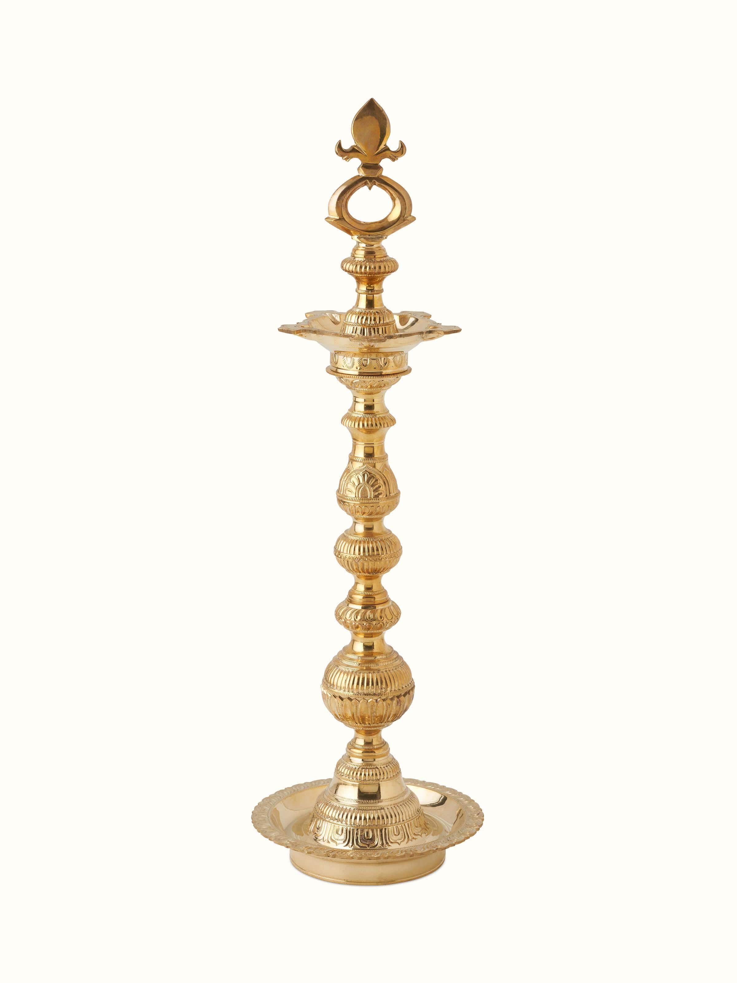 Front view of Vilakku Carved Brass Stand Diya displaying its intricate carvings and brass finish.