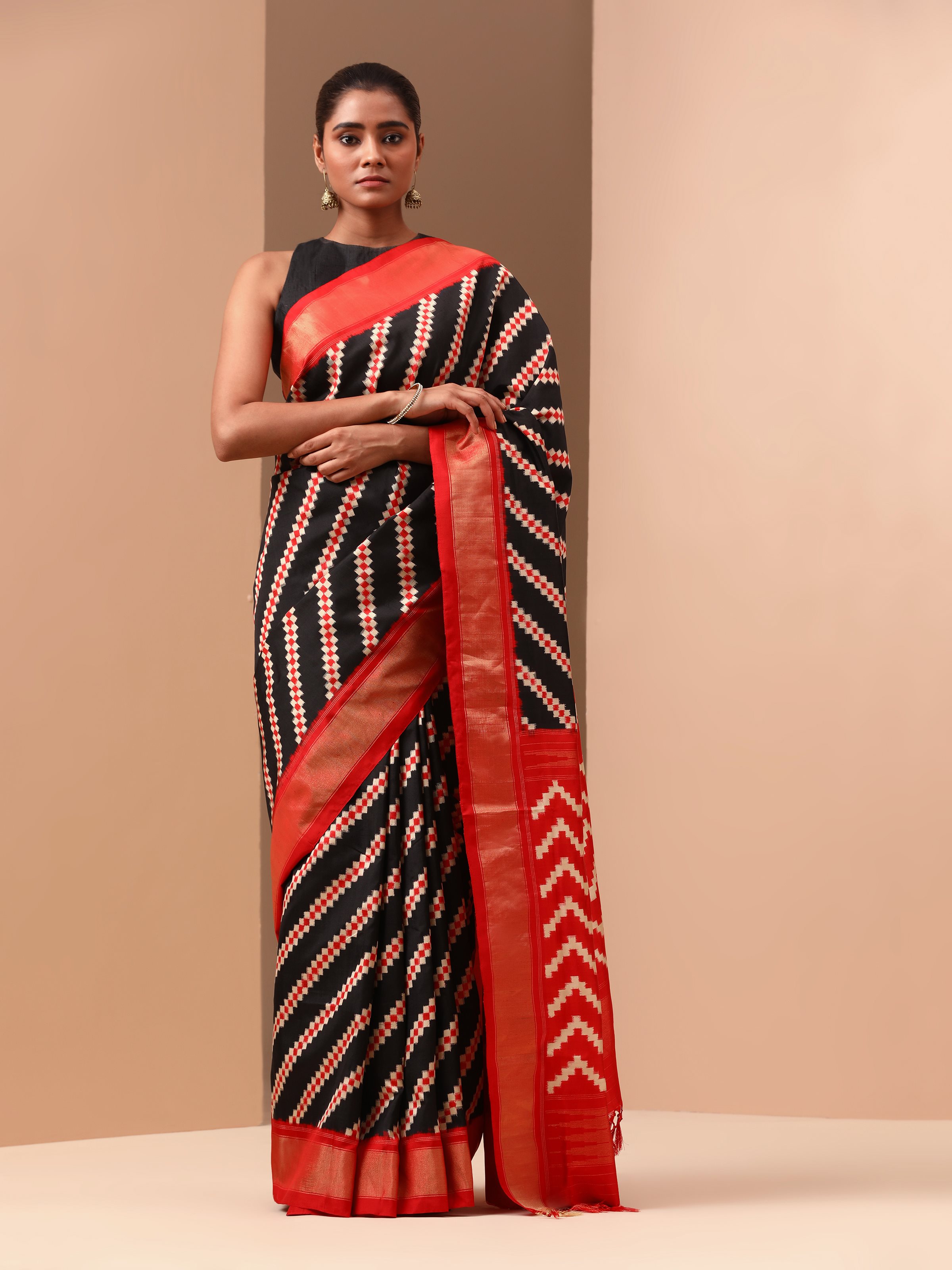 Angled view showcasing intricate double Ikat weaving on navy blue silk saree.