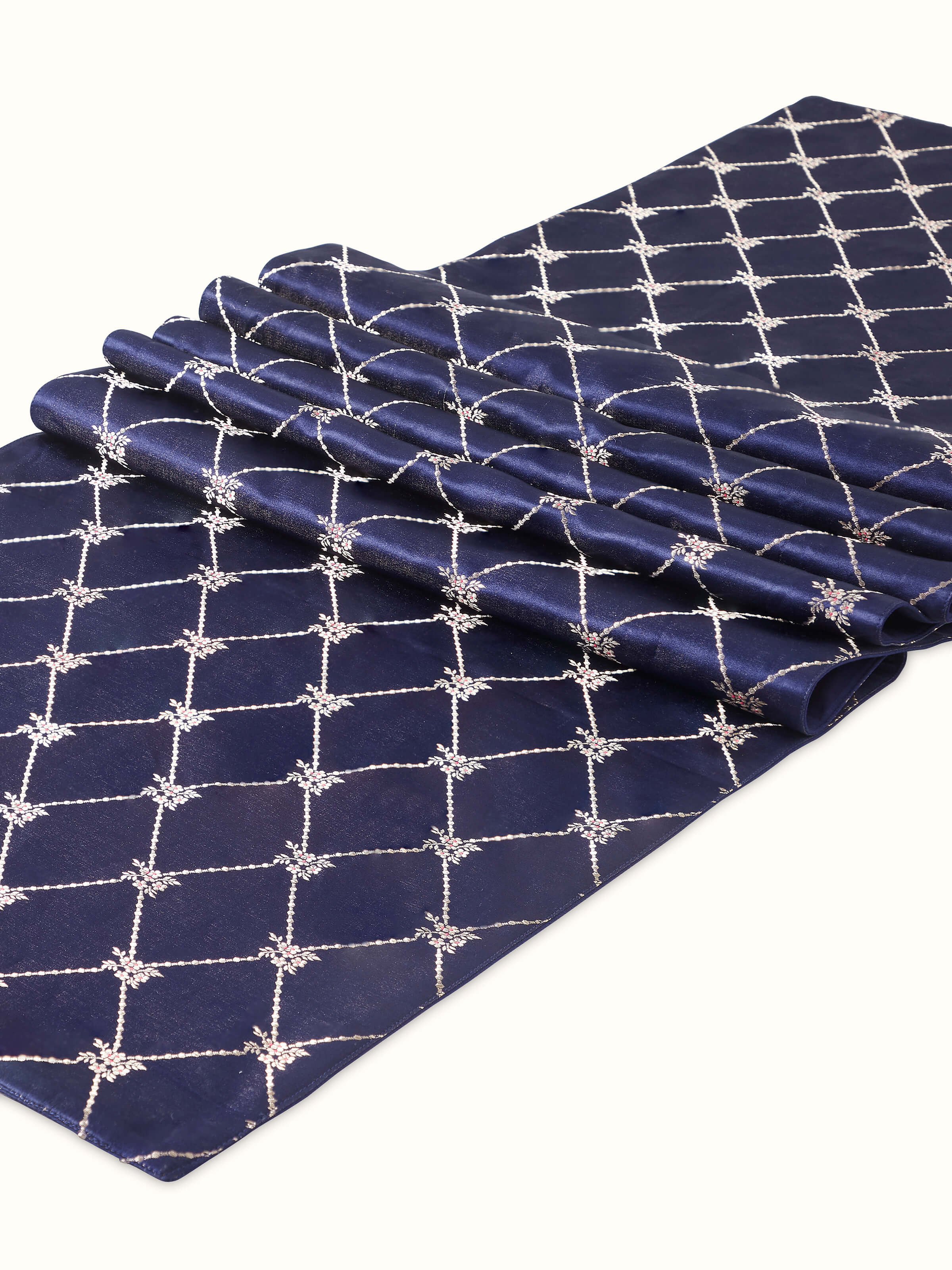 Angled shot of detailed zari weaving and ornate Banarasi patterns.