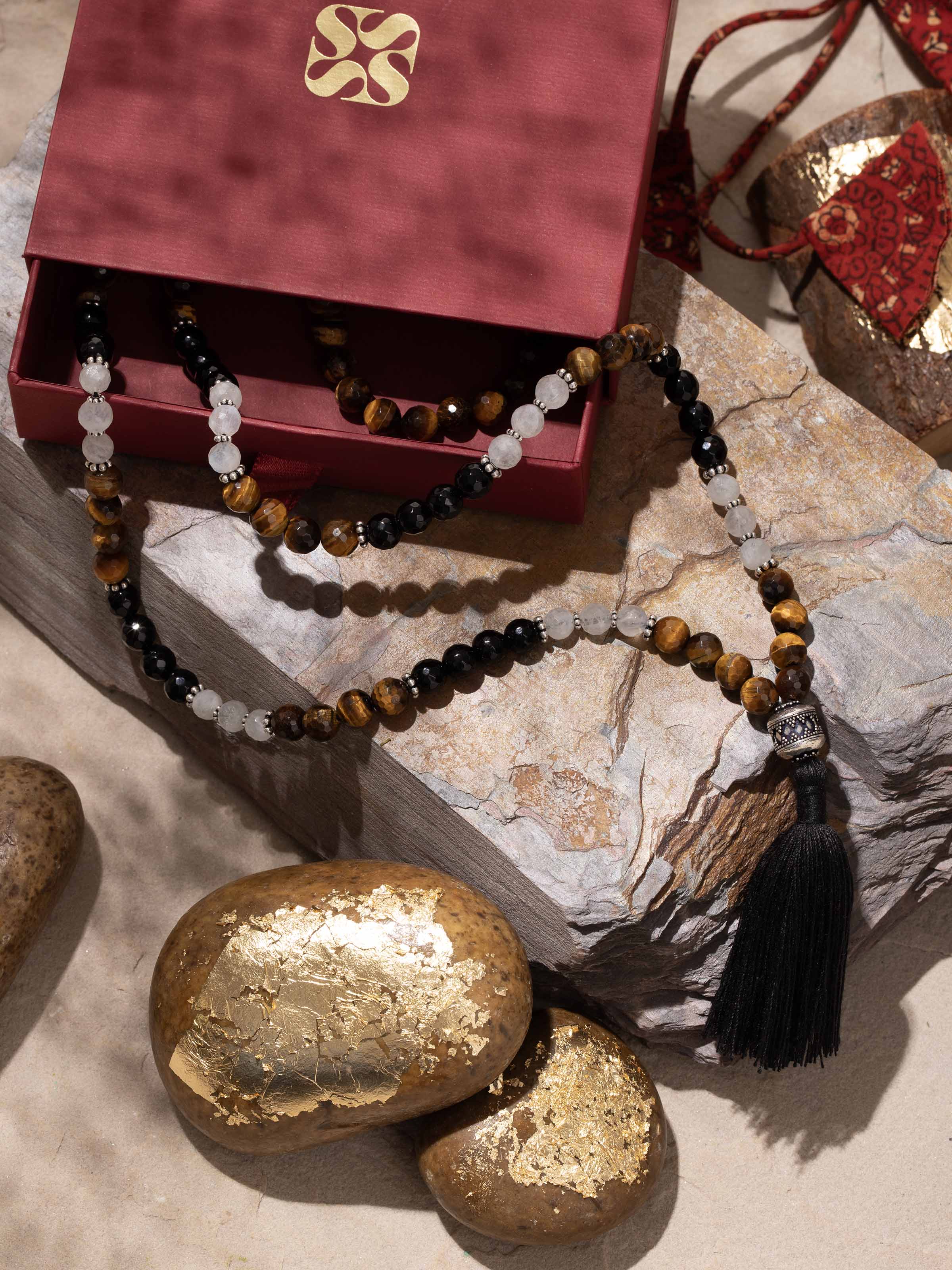 Lifestyle image of gemstone mala worn around neck, highlighting polished beads and spiritual style