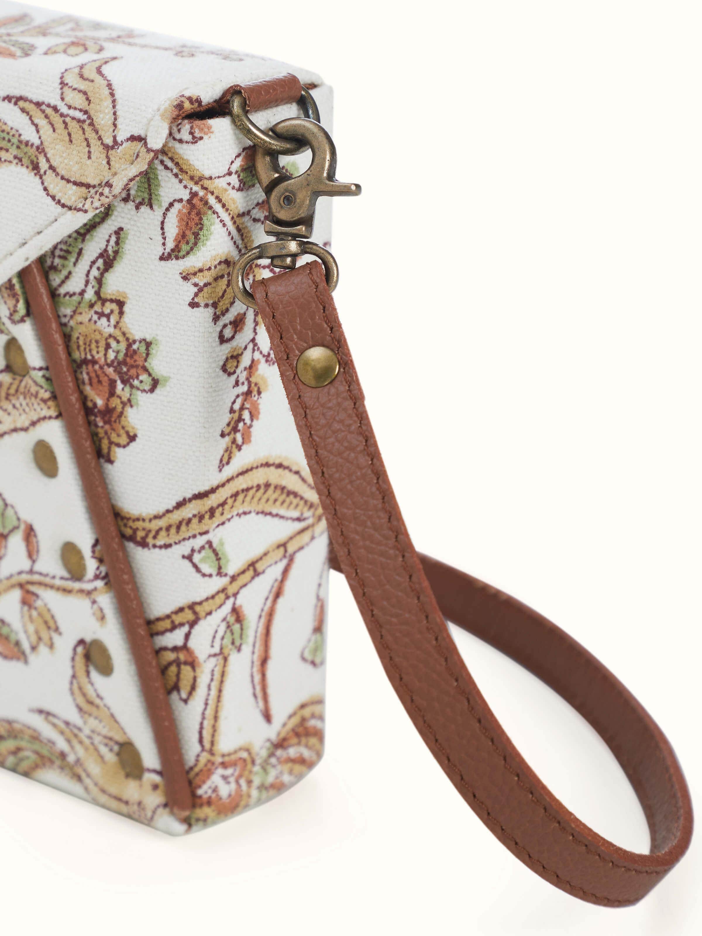 Back view of mustard leather and textile sling bag showing zipper and strap