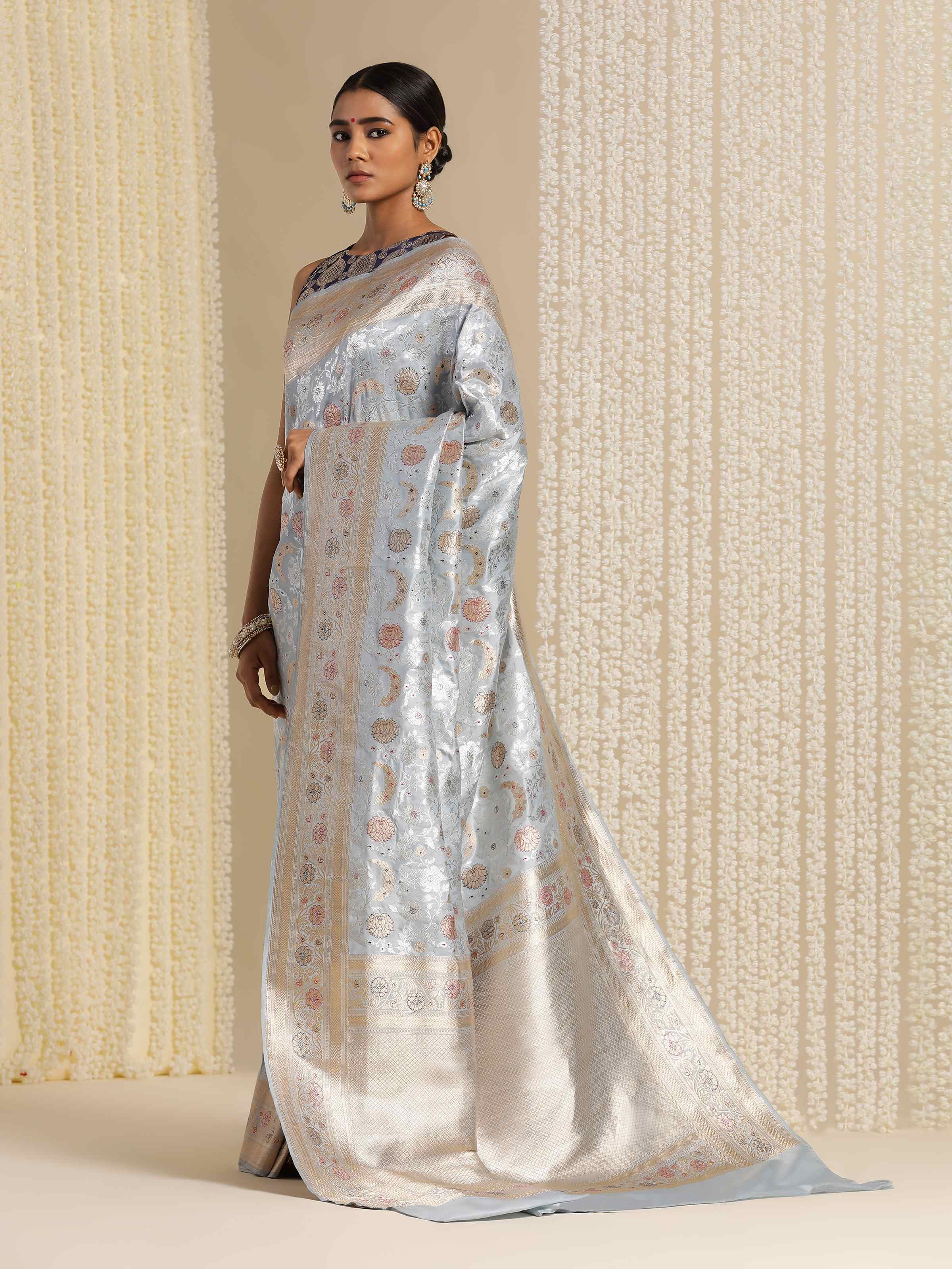 Lifestyle view of ice blue Banarasi saree styled with complementary accessories in a traditional look.
