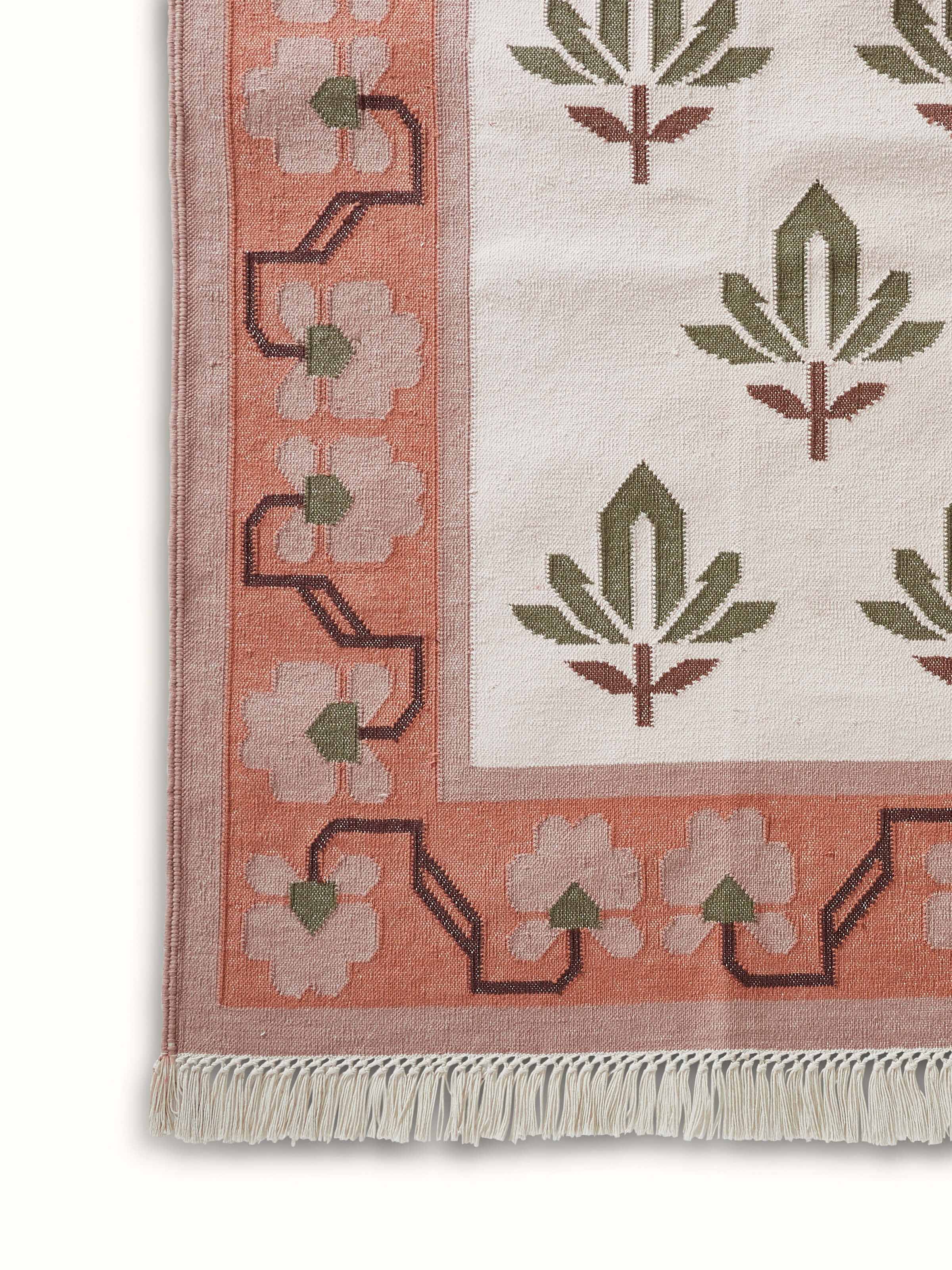 Angled view of Contemporary lotus blush lawan cotton panja dhurrie, highlighting its design and overall look.