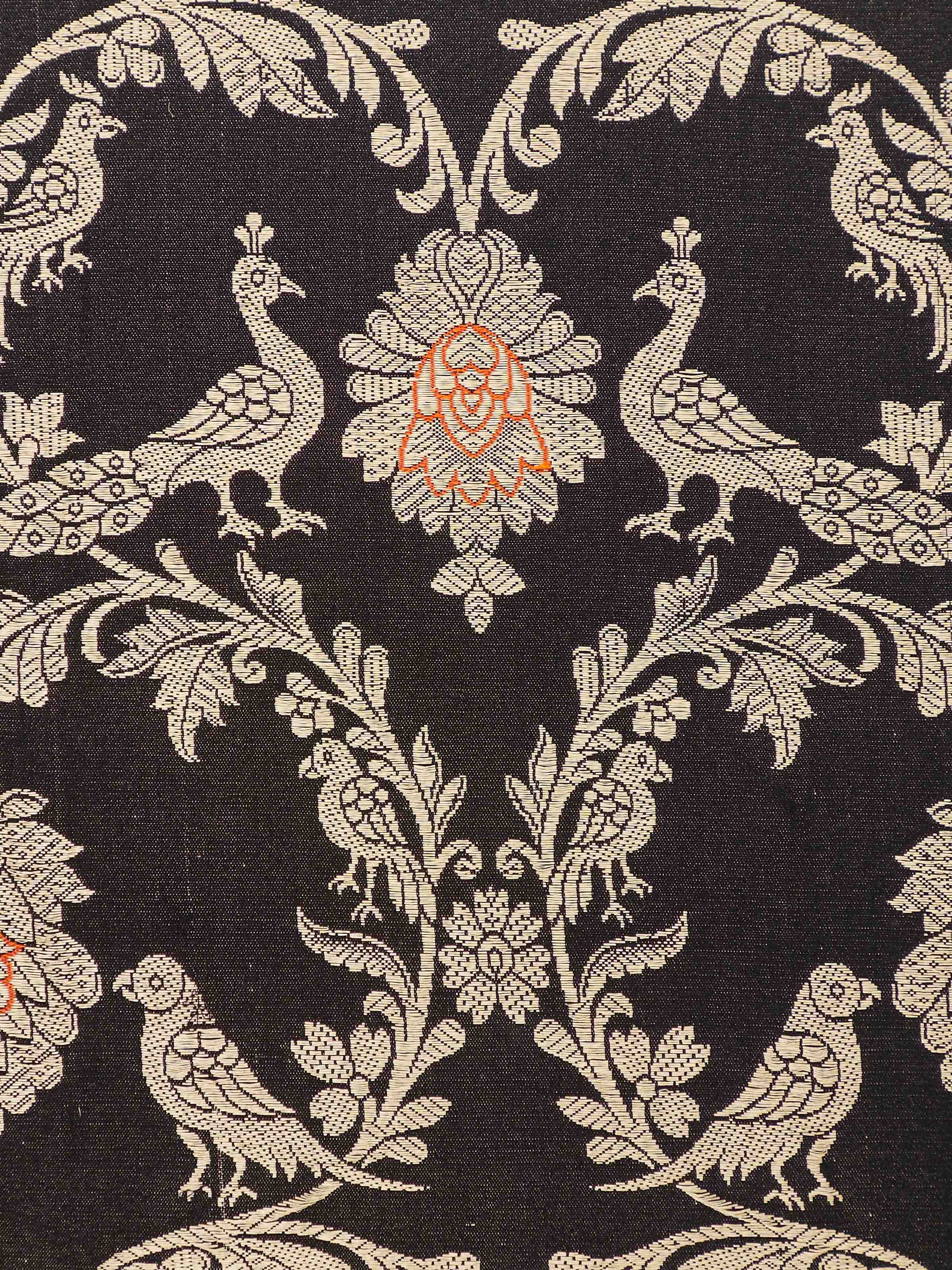 Detail shot of intricate golden jaal motifs on black silk background.