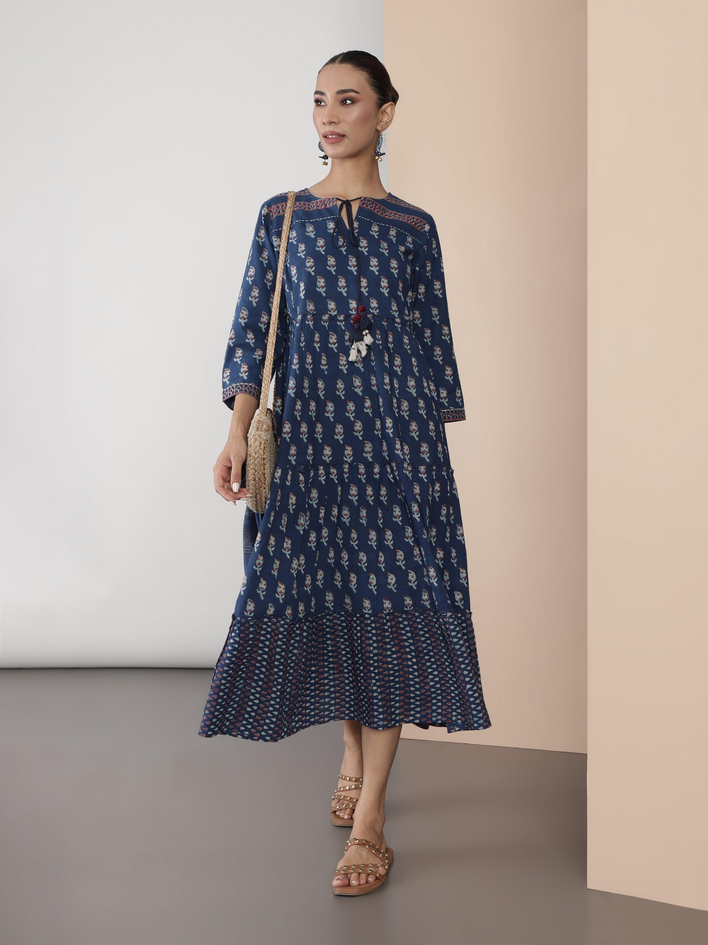 Lifestyle view of blue cotton Dabu block printed A-line midi dress styled with minimal accessories