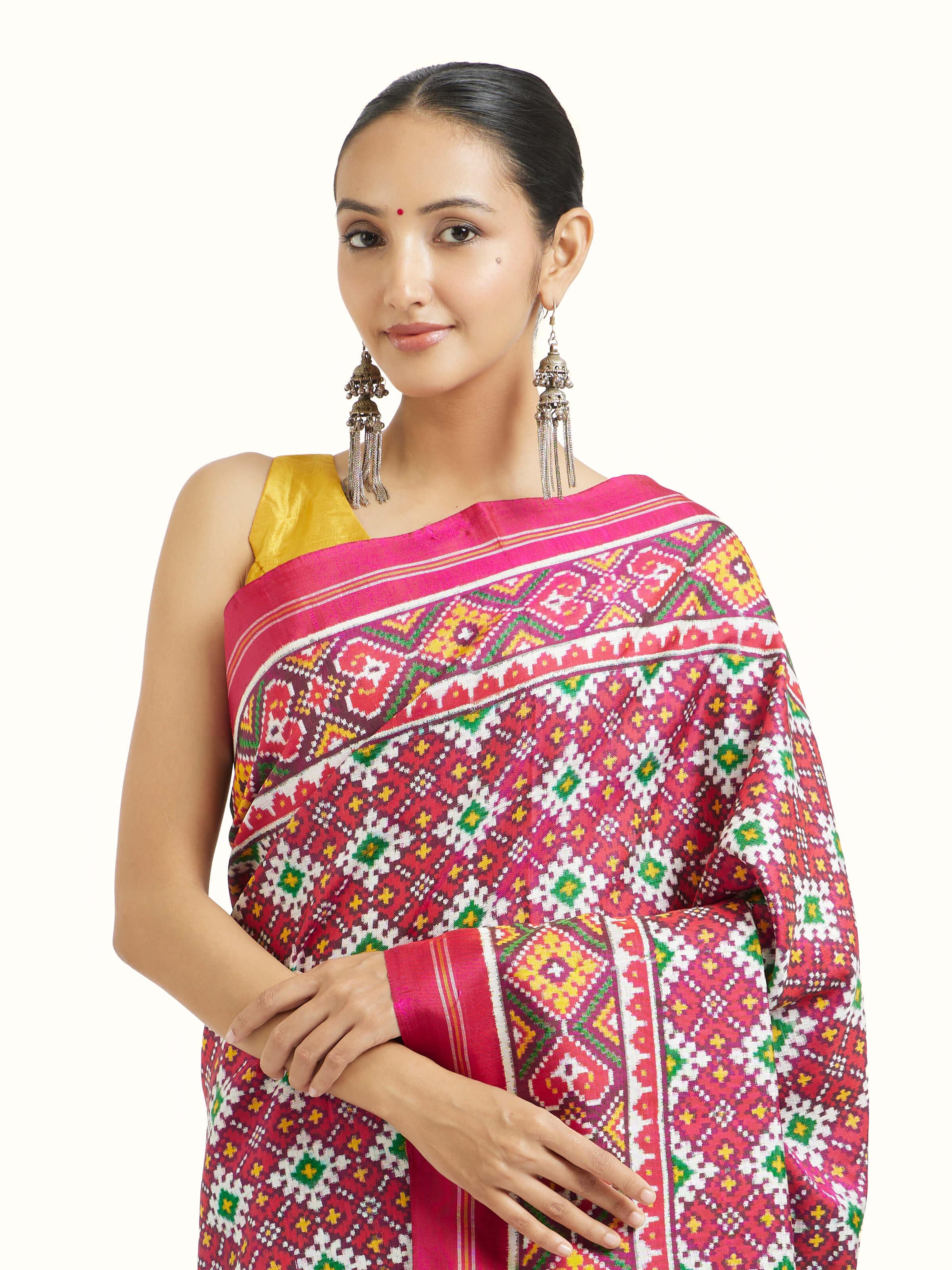 Angled view of pink mulberry silk Patan Patola saree highlighting geometric motifs