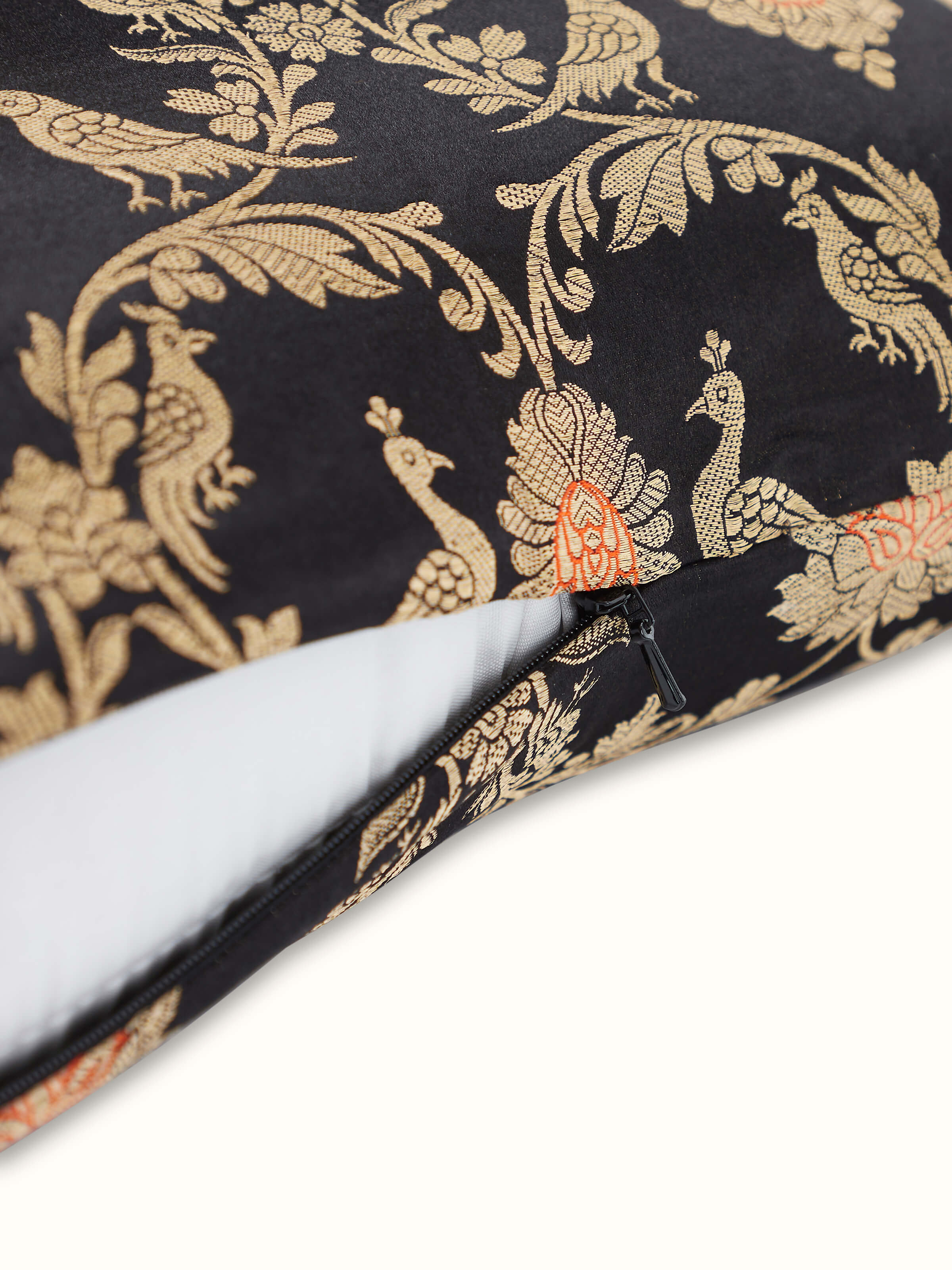 Angled view of black silk cushion cover showing rich Jaal pattern
