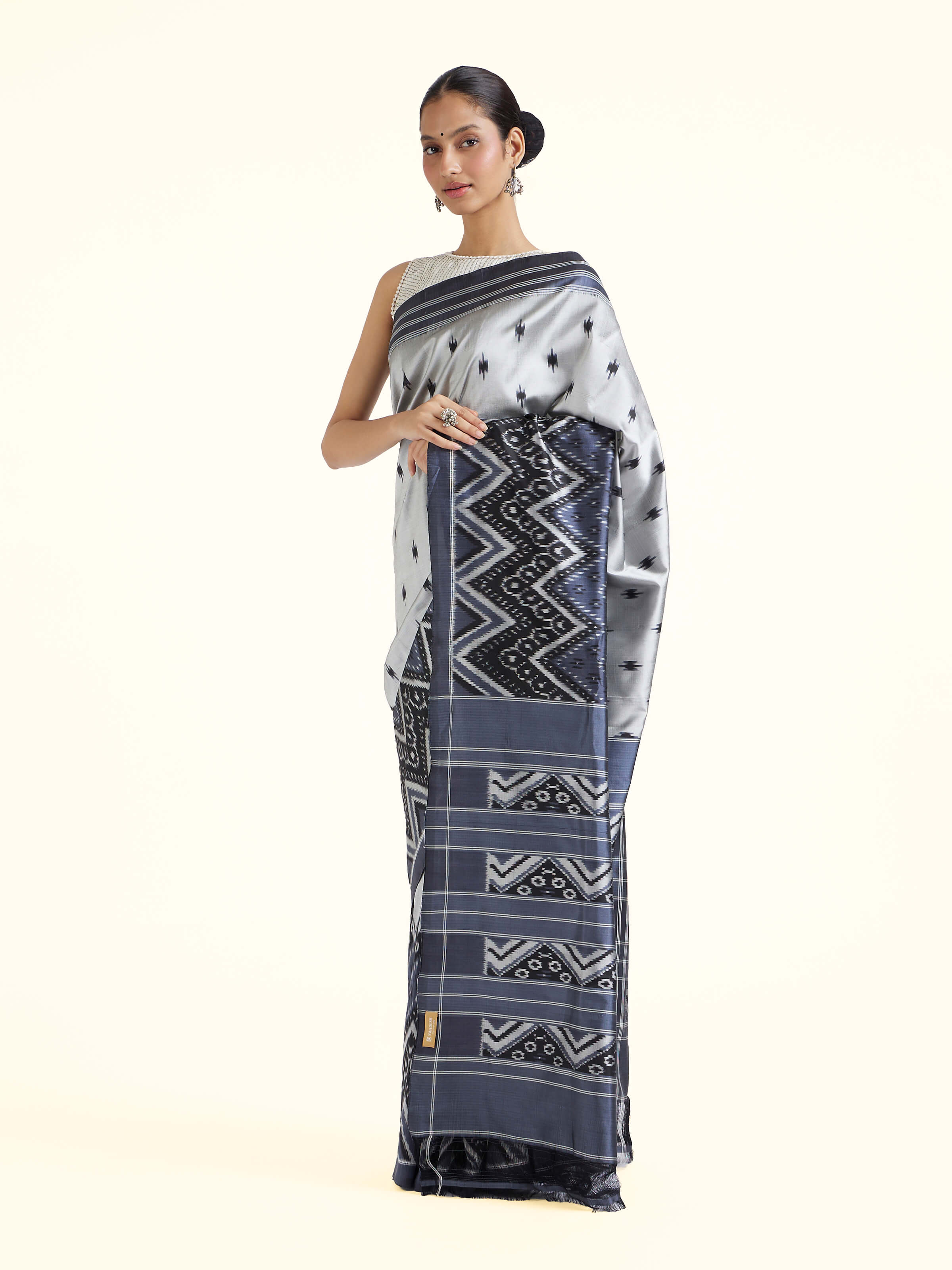 Side view of off-white mulberry silk ikat saree highlighting silk drape