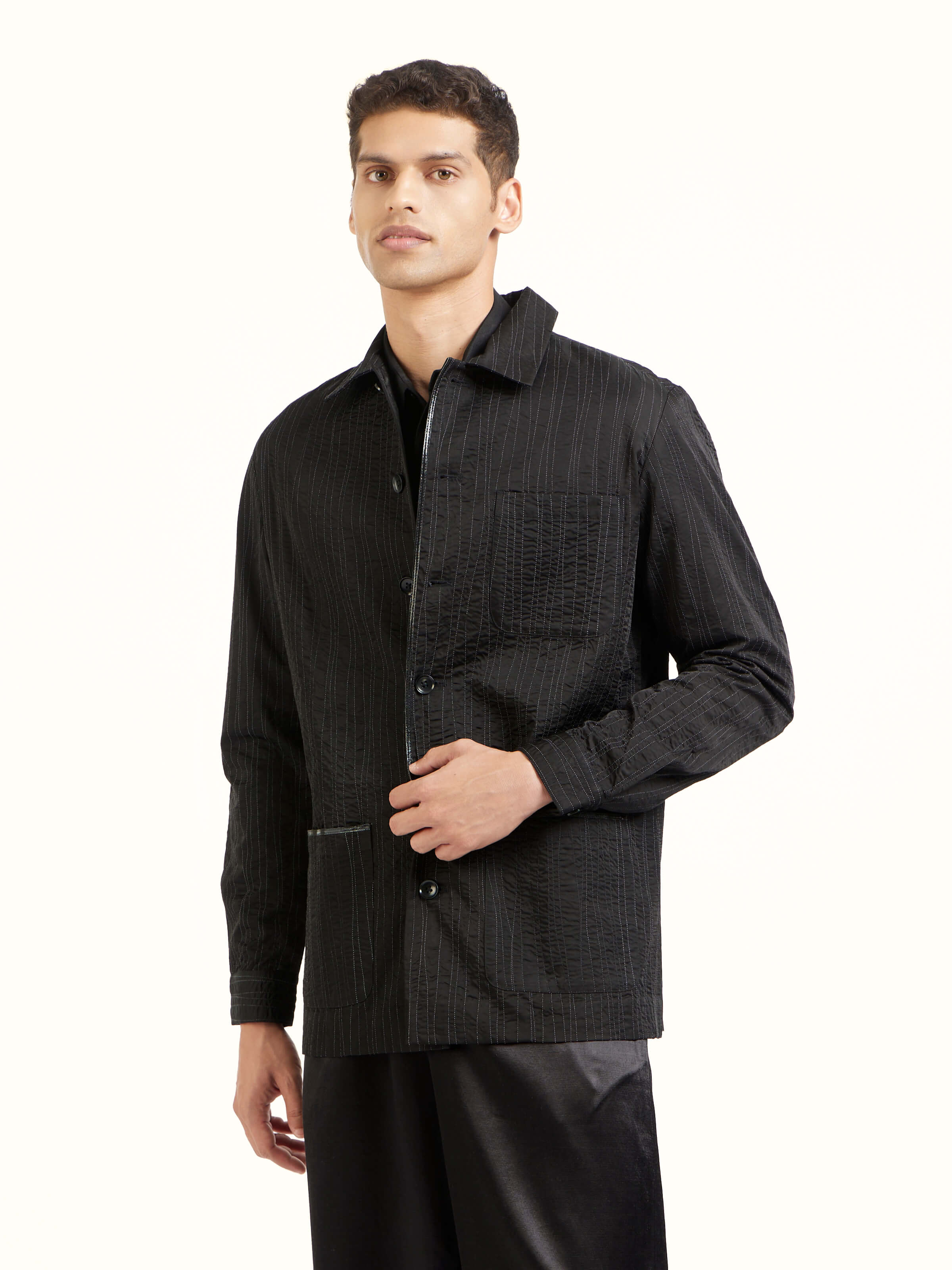 Angled view of black quilting ethnic jacket emphasizing surface detailing