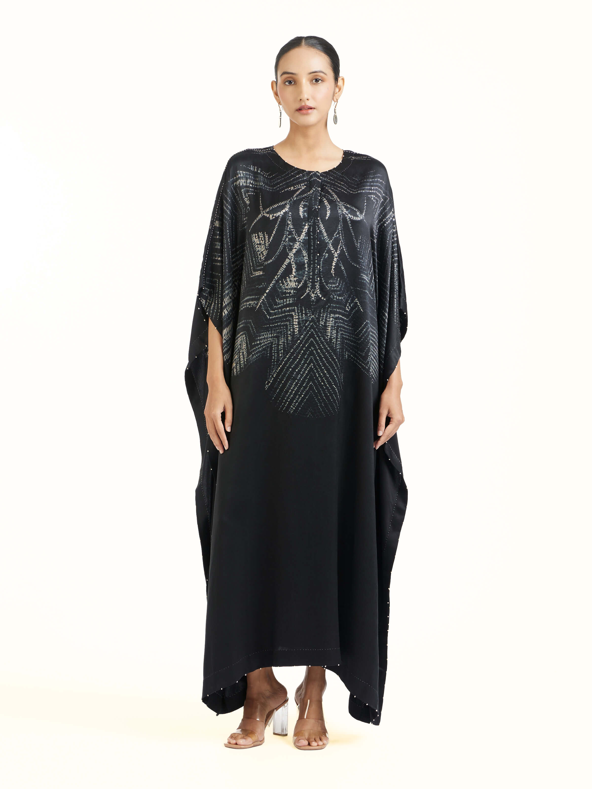 Front view of black satin shibori kaftan with fluid drape
