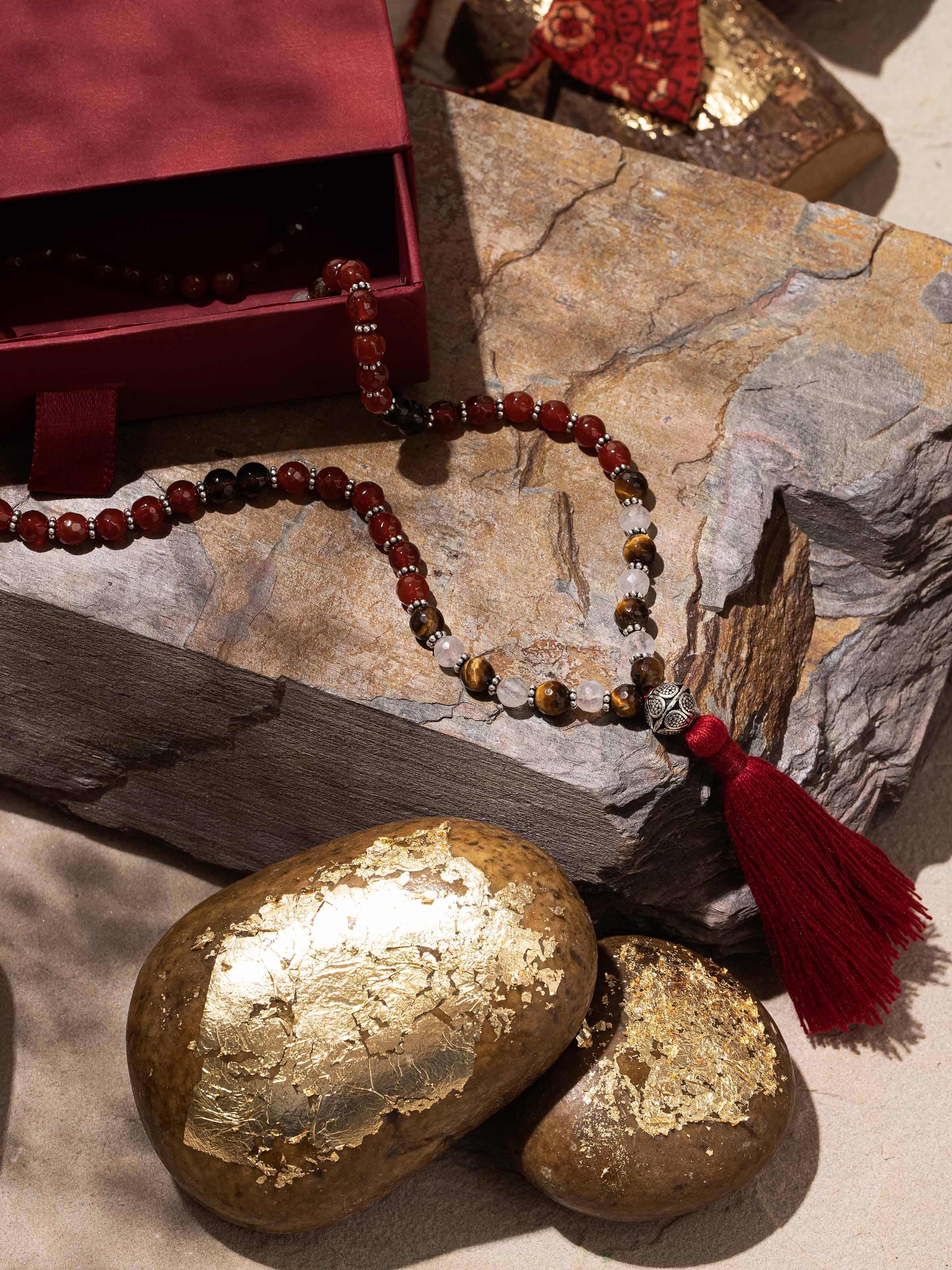 Side view showing gemstone variation and silver detailing on handcrafted mala