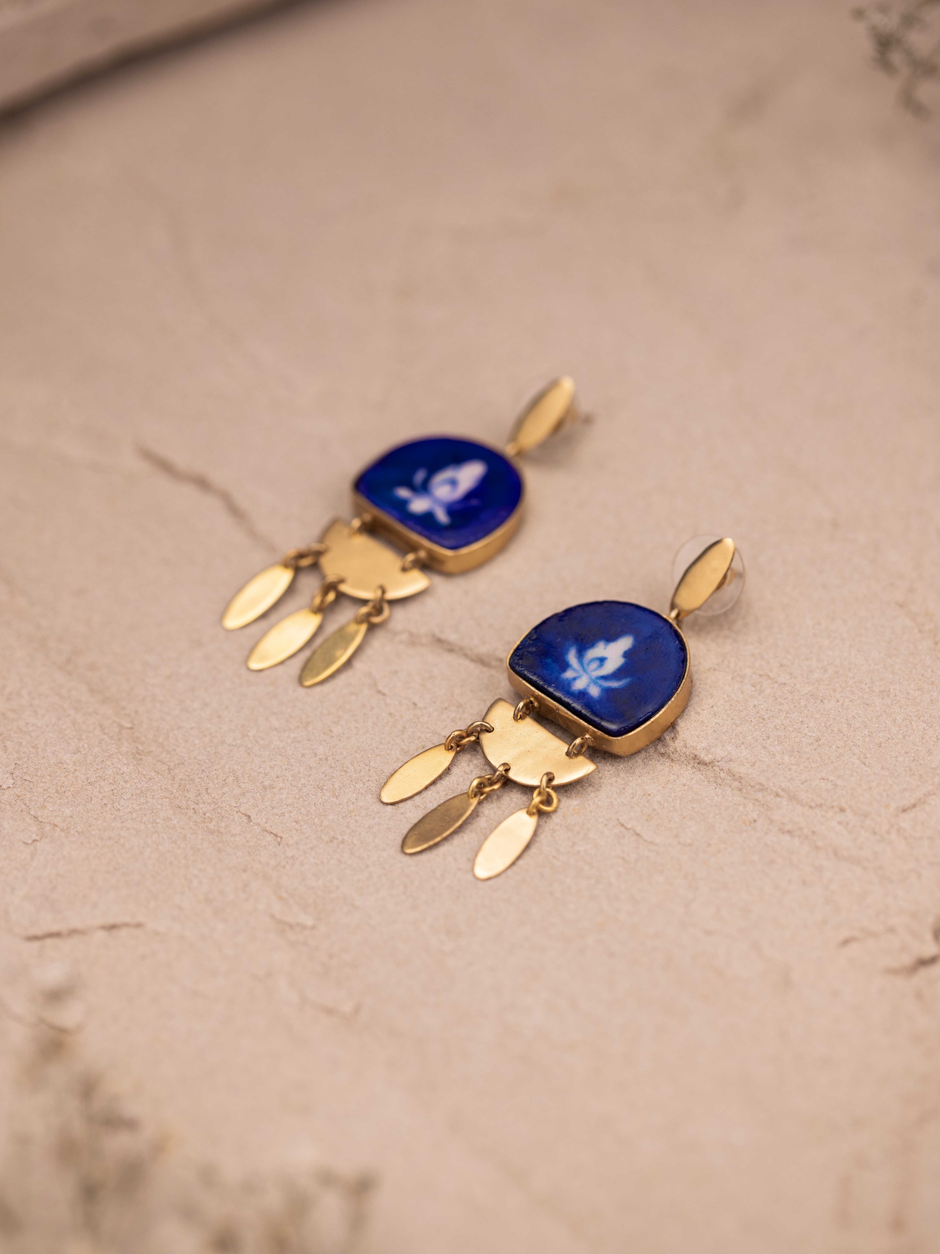 Angled view of blue pottery drop earrings featuring elegant design and vibrant colors