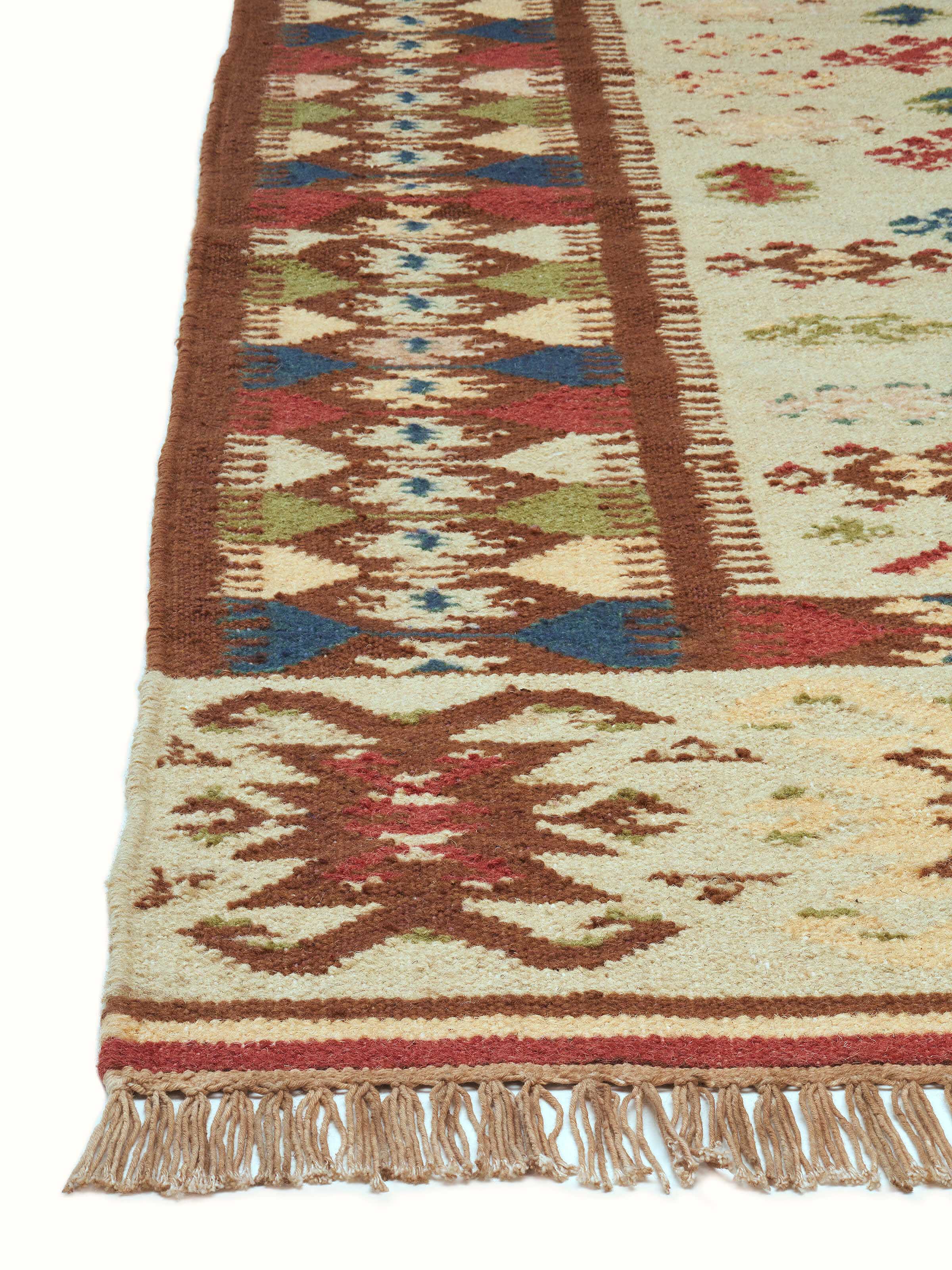 Angled view of Traditional kilim beige salawas wool & cotton panja dhurrie, displaying the pattern and color variations.
