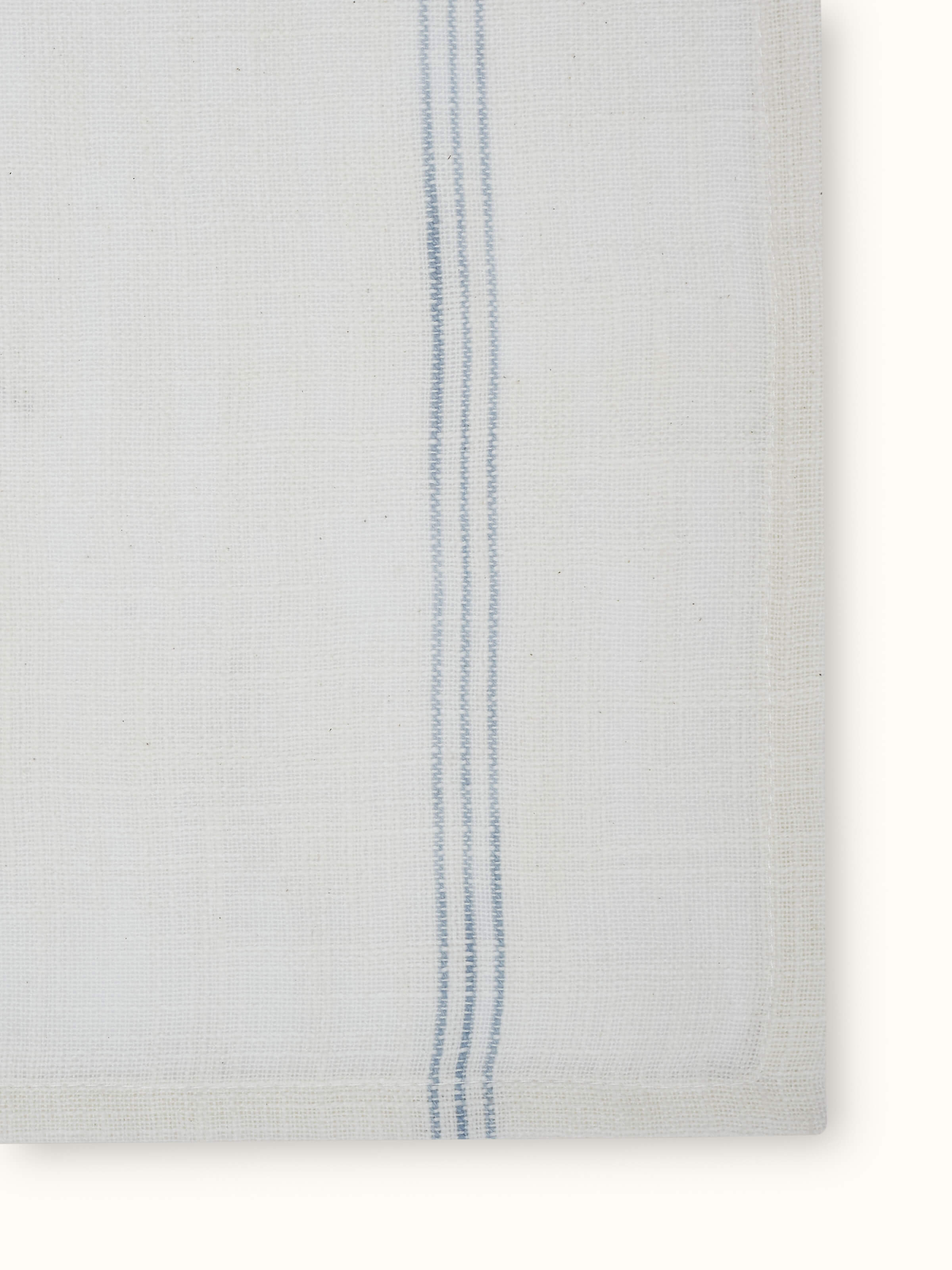 Angled view of Arth light blue stripe cotton handloom dinner napkins showcasing folded texture and woven stripe detailing.