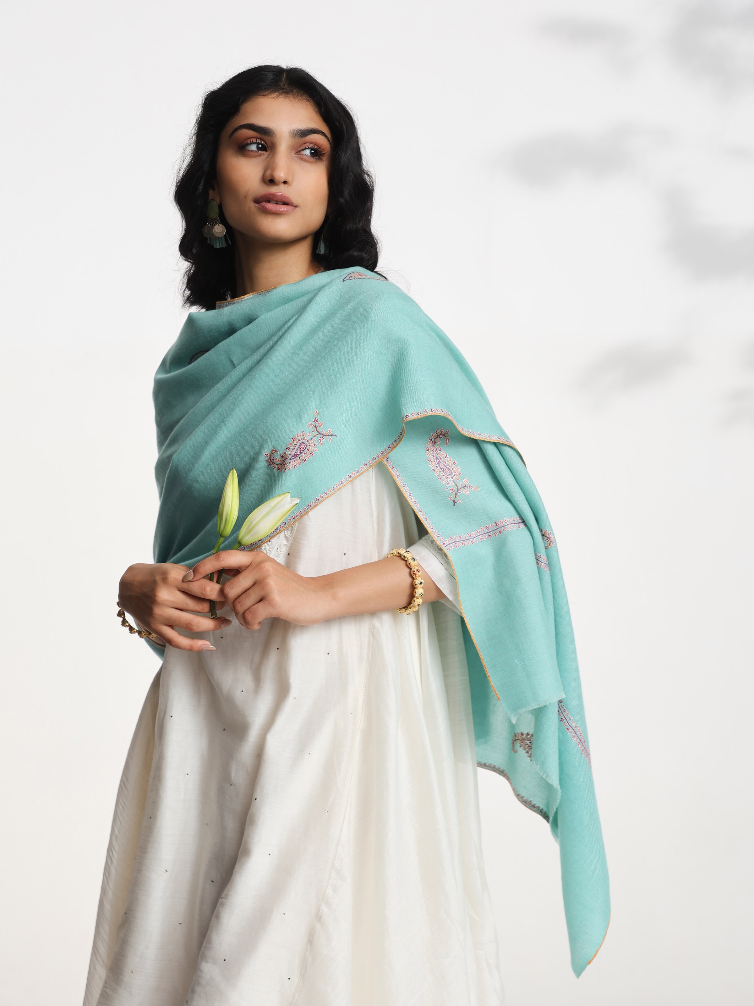 Angled view of rust jalidar sozni embroidered stole emphasizing fine stitch work