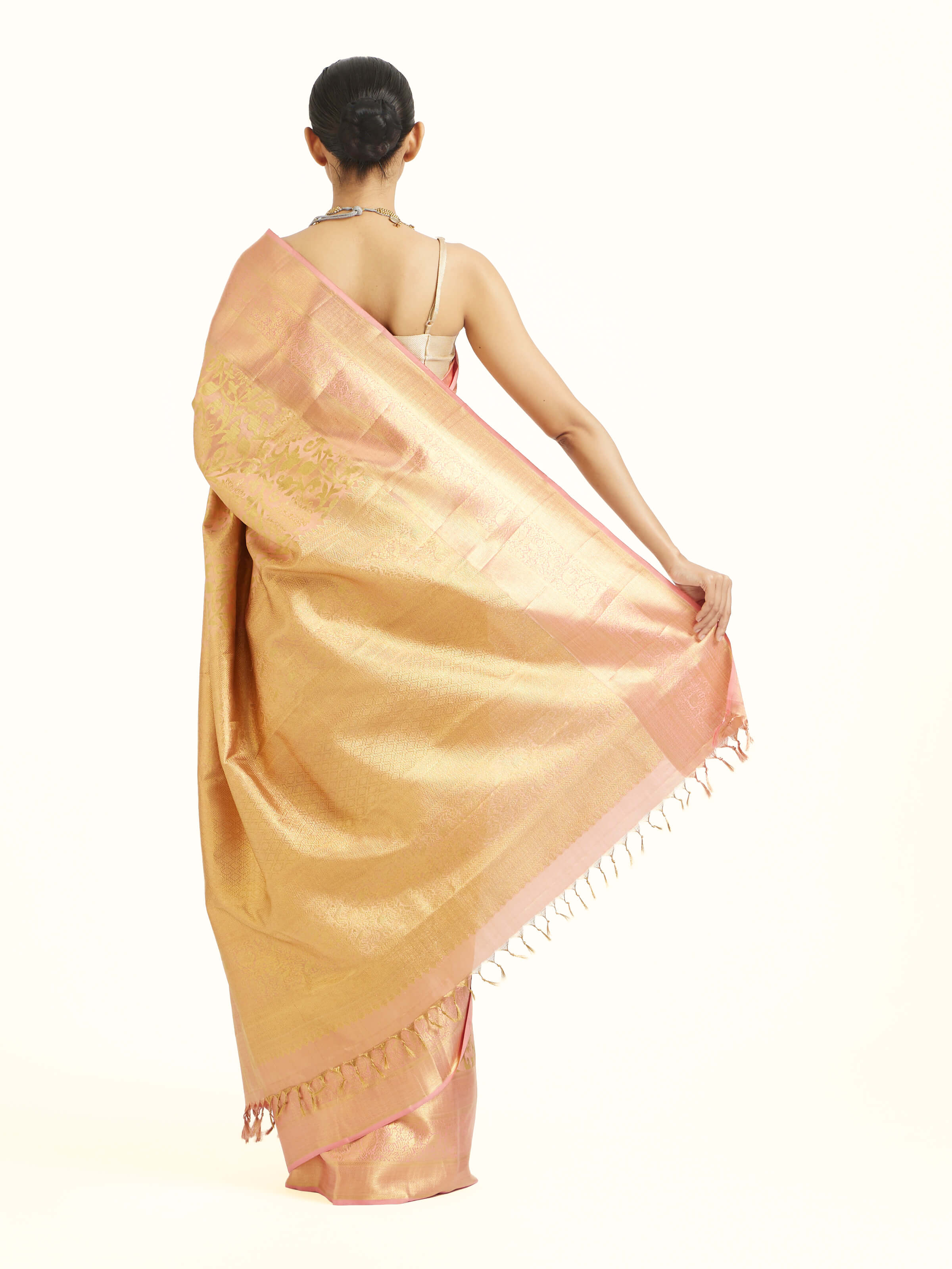 Back view of peach silk Kancheepuram saree displaying ornate pallu design