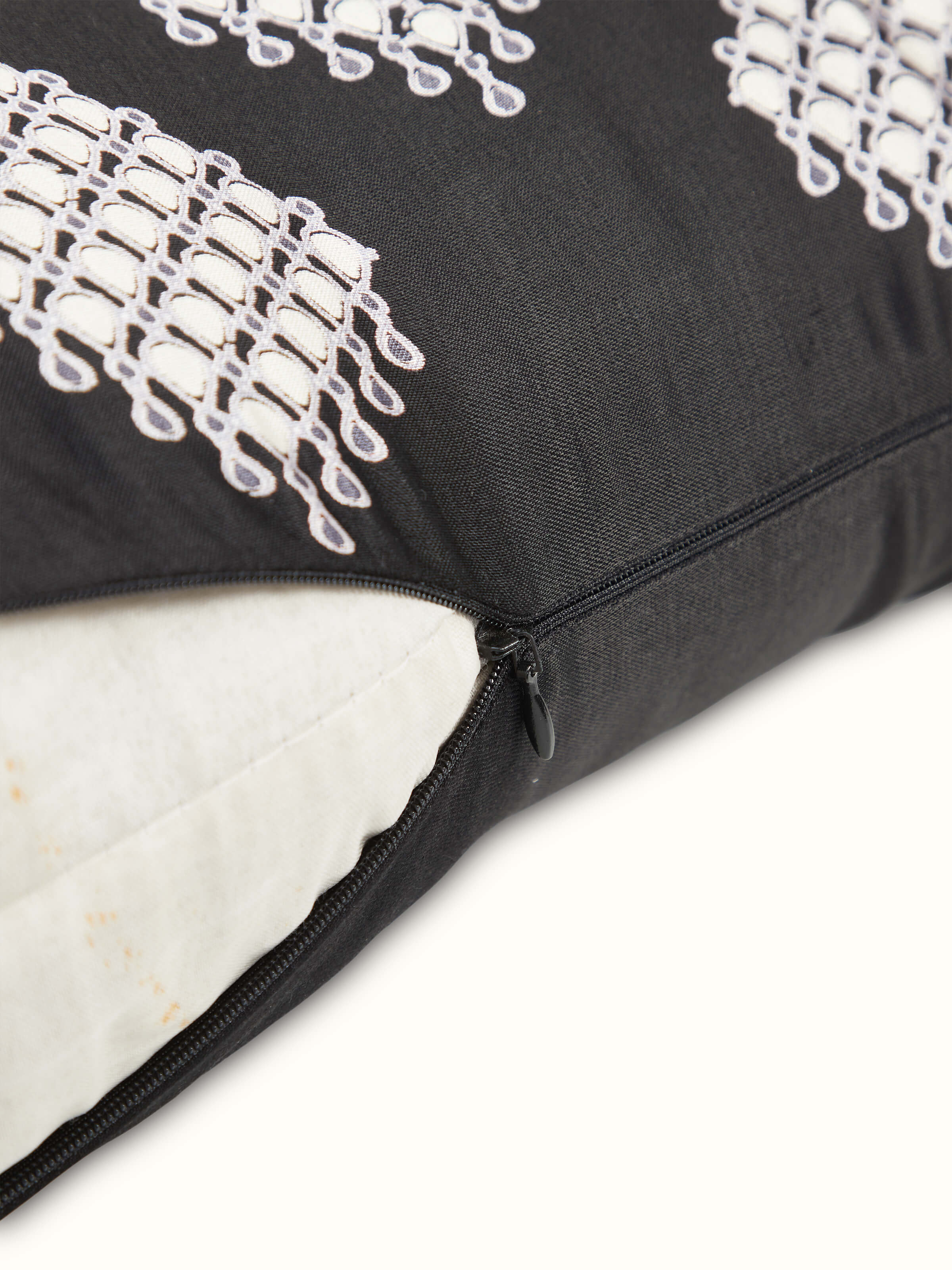 Angled view: Angled view of Rambagh black viscose cotton cushion cover showing bold block print design