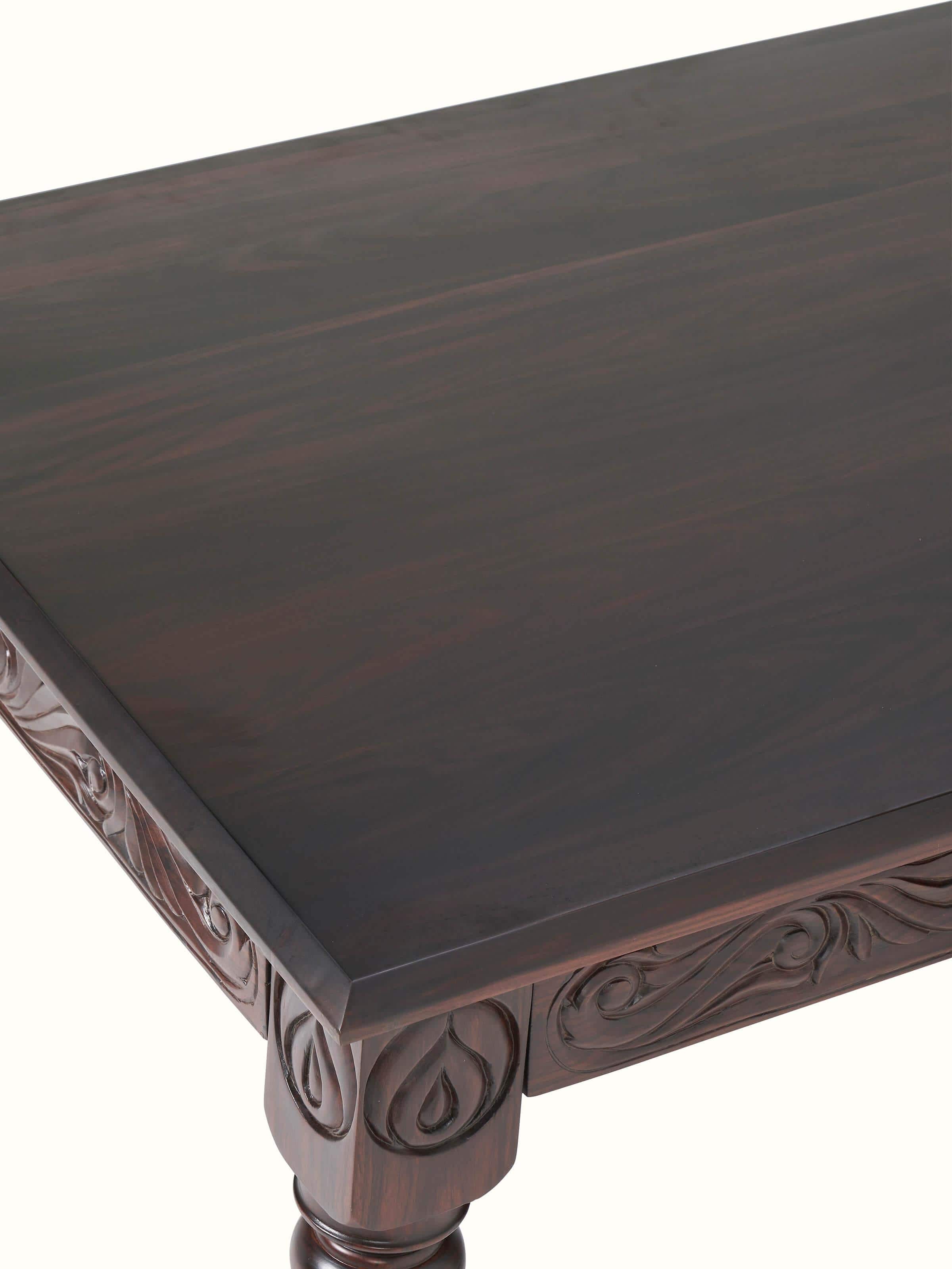Close-up of carved rosewood 6-seater dining table surface, focusing on the detailed carvings and polished finish