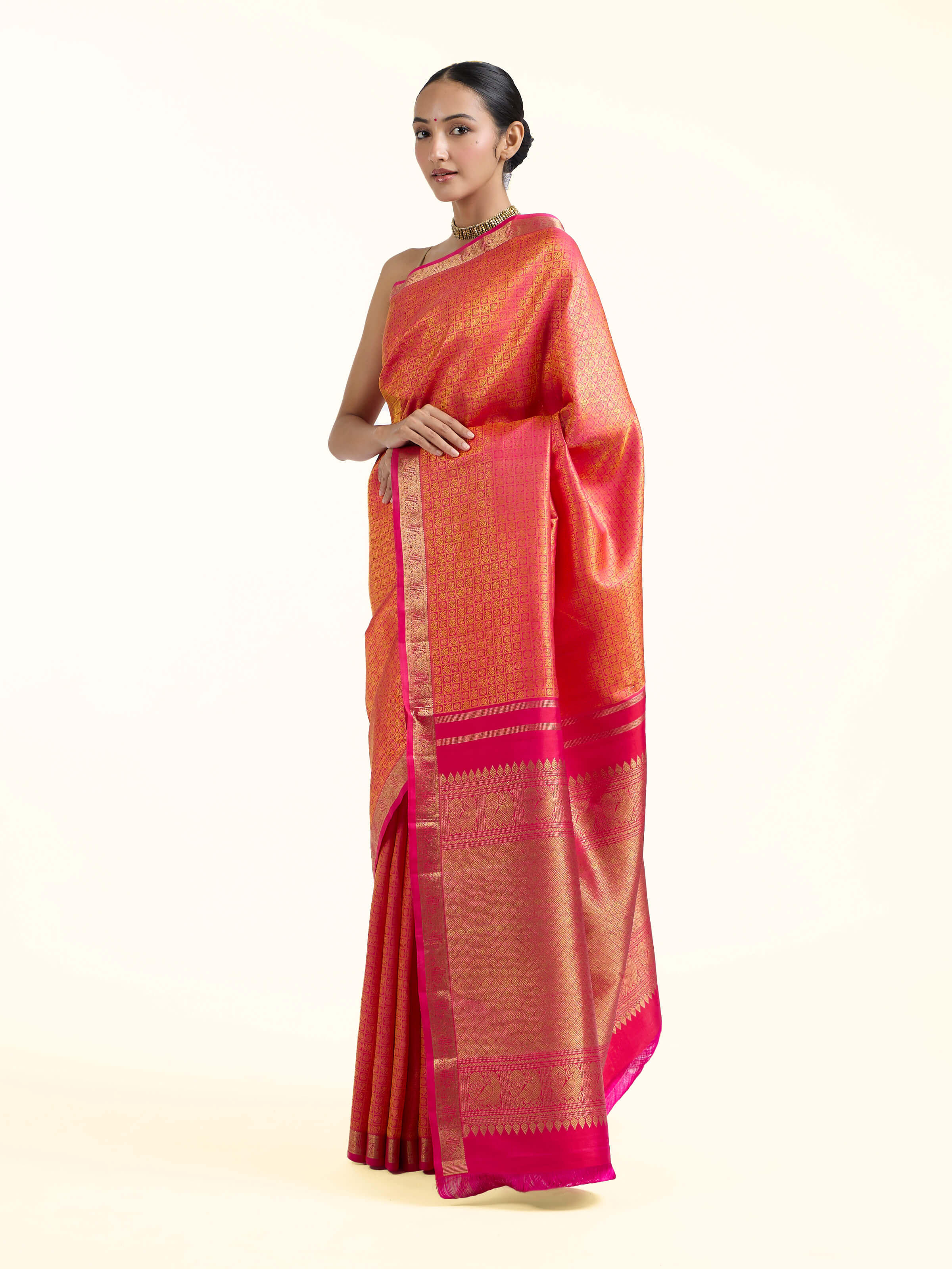 Side view of orange silk Kancheepuram saree with graceful drape and contrast border