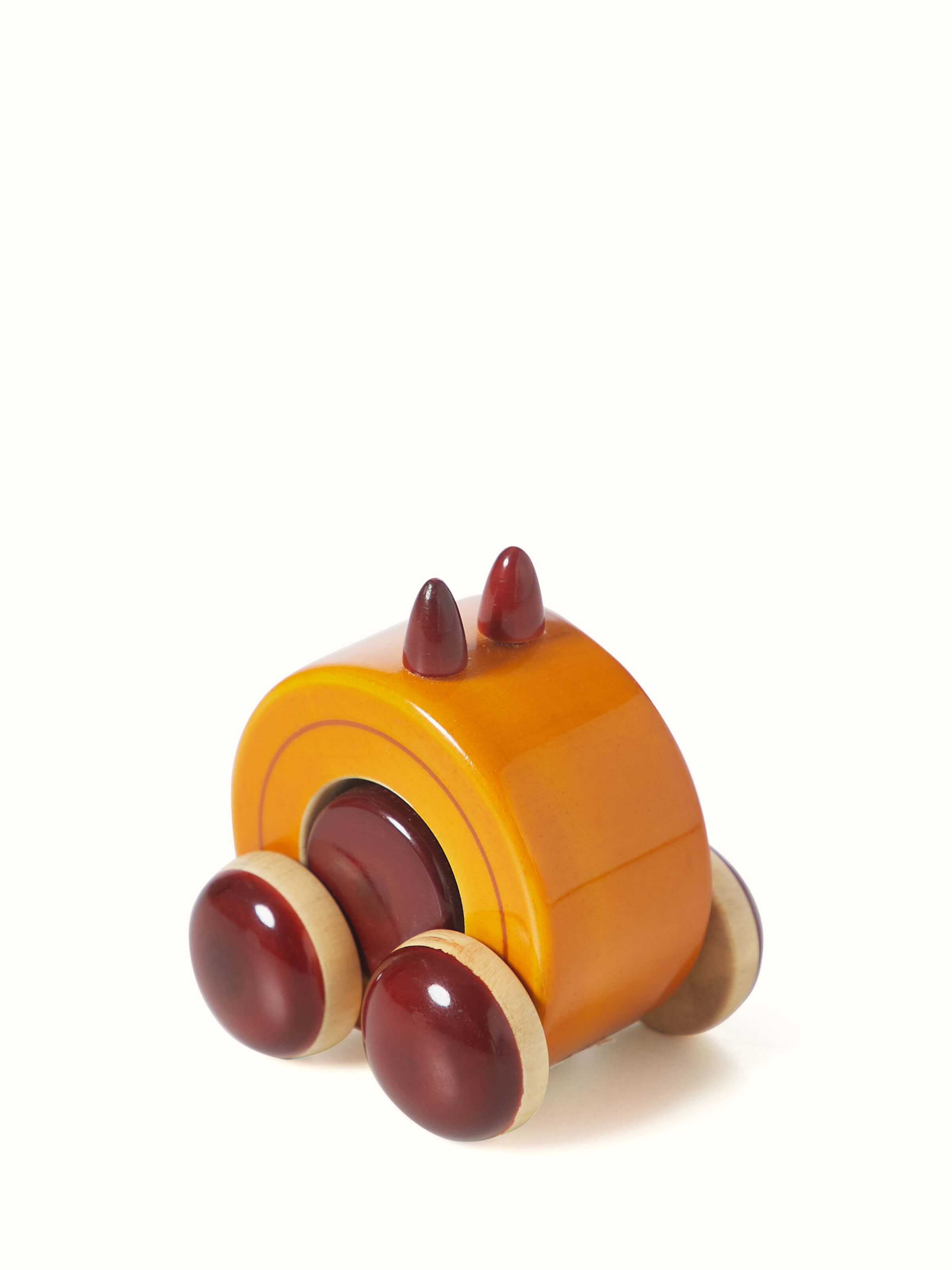 Angled view of Channapatna Ivory Wood Moee Toy Yellow with vibrant colors
