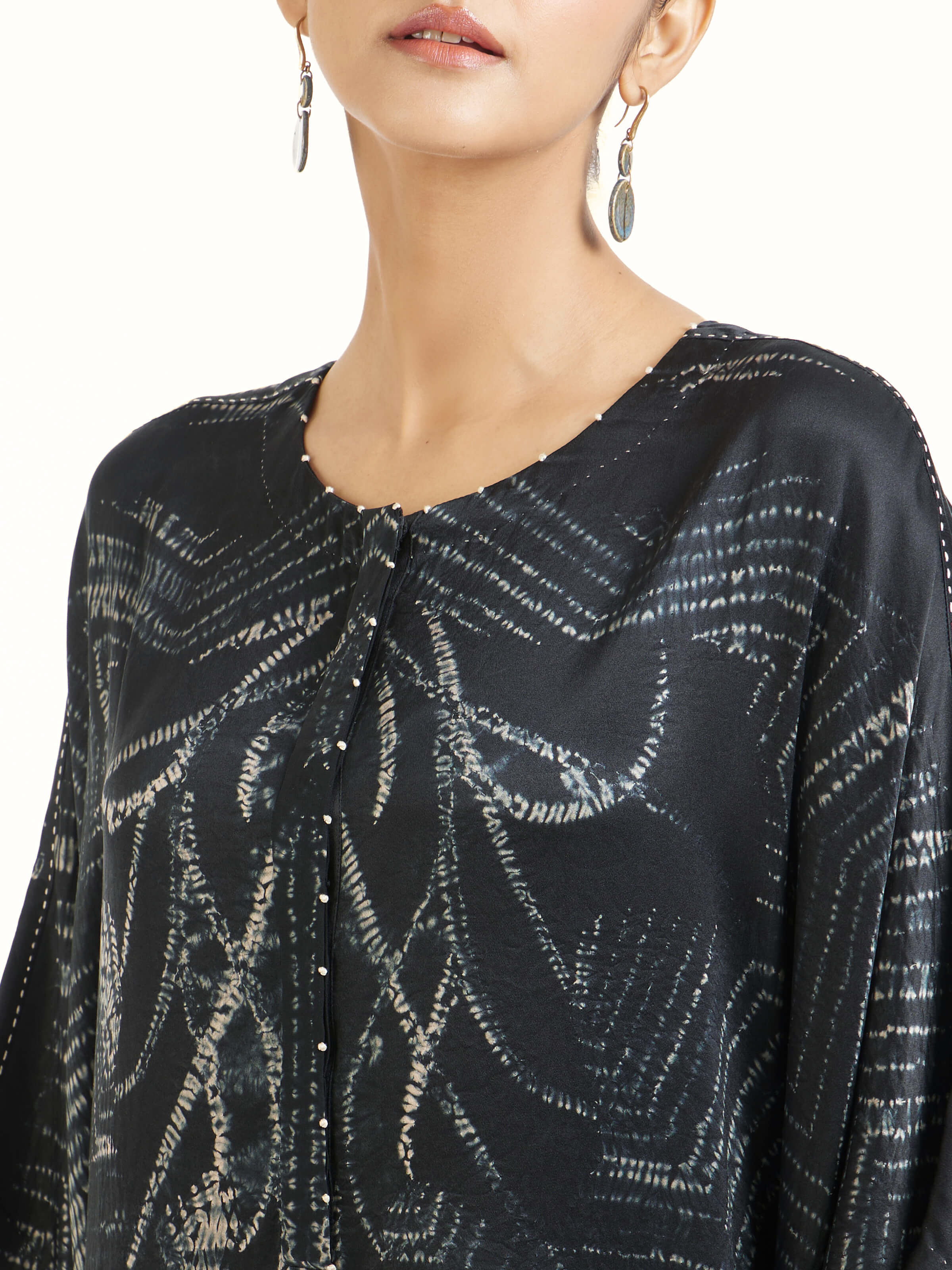 Detail view of black satin shibori kaftan showing satin sheen