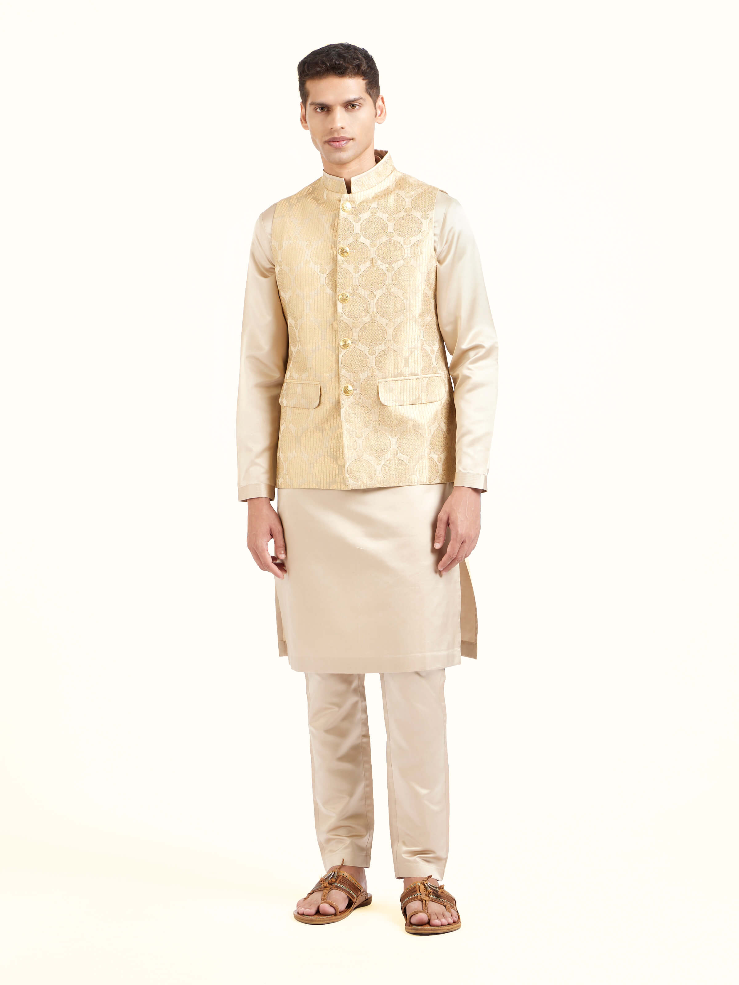 Front view of beige silk Banarasi sleeveless jacket showcasing rich woven motifs