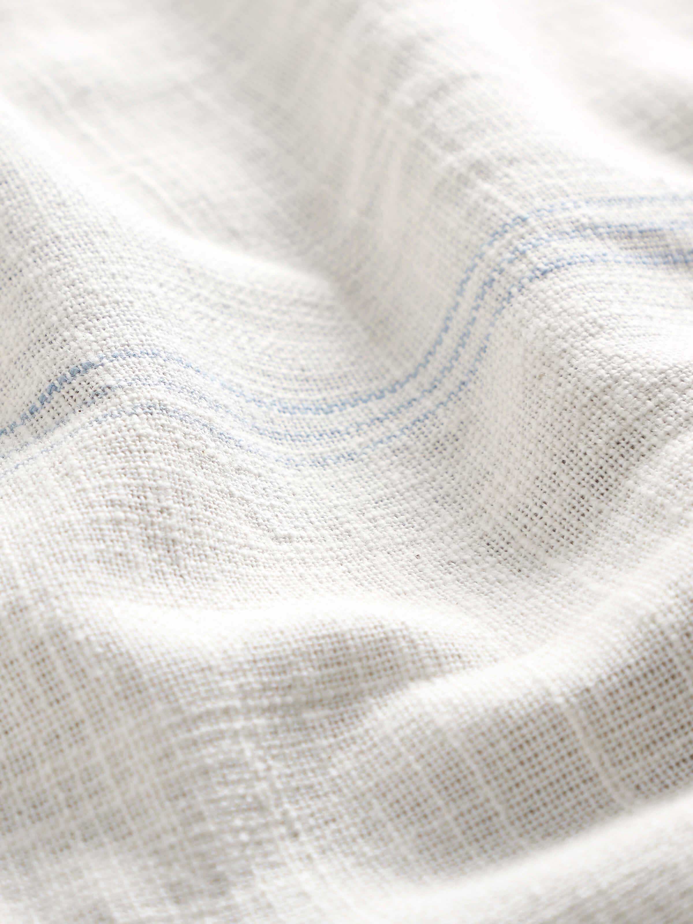 Detail shot of Arth light blue stripe cotton handloom table cover focusing on weave quality and stitched edge finish.