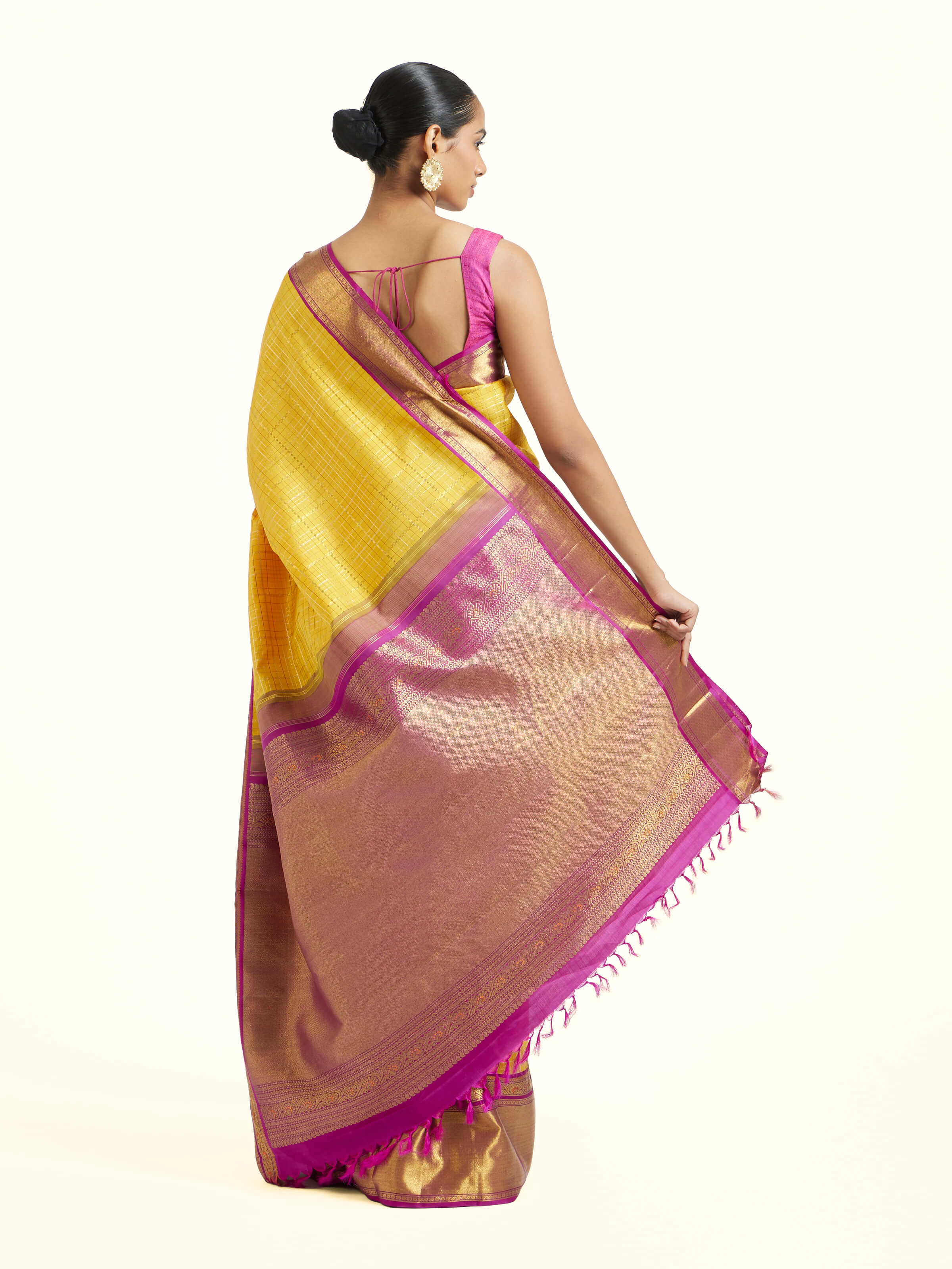 Back view of yellow silk Kancheepuram saree displaying ornate pallu