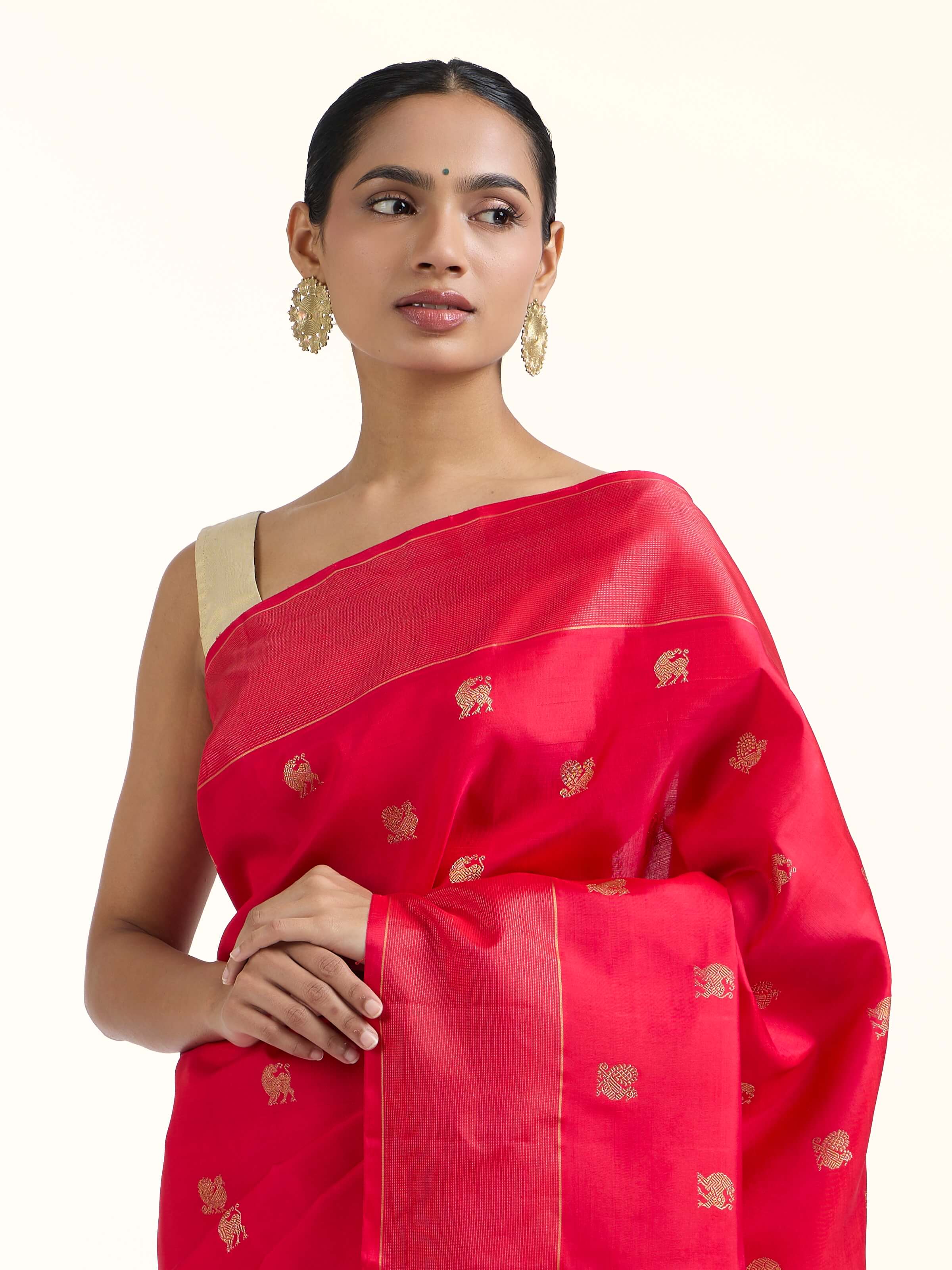 Angled view of red silk Kancheepuram saree highlighting traditional weave and sheen