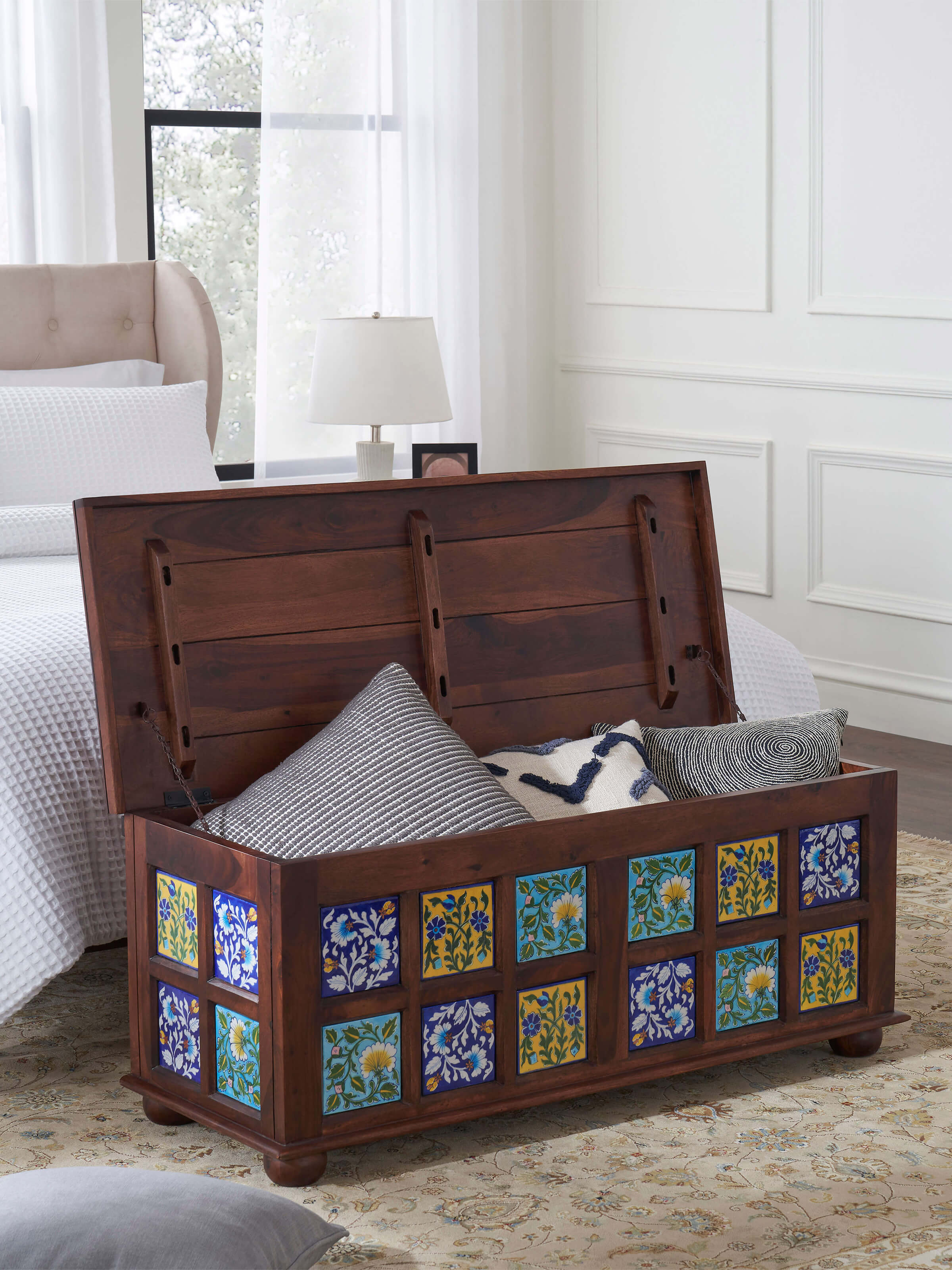 Sheesham wood trunk with blue pottery detailing, emphasizing the rich texture and traditional aesthetic of the design.
