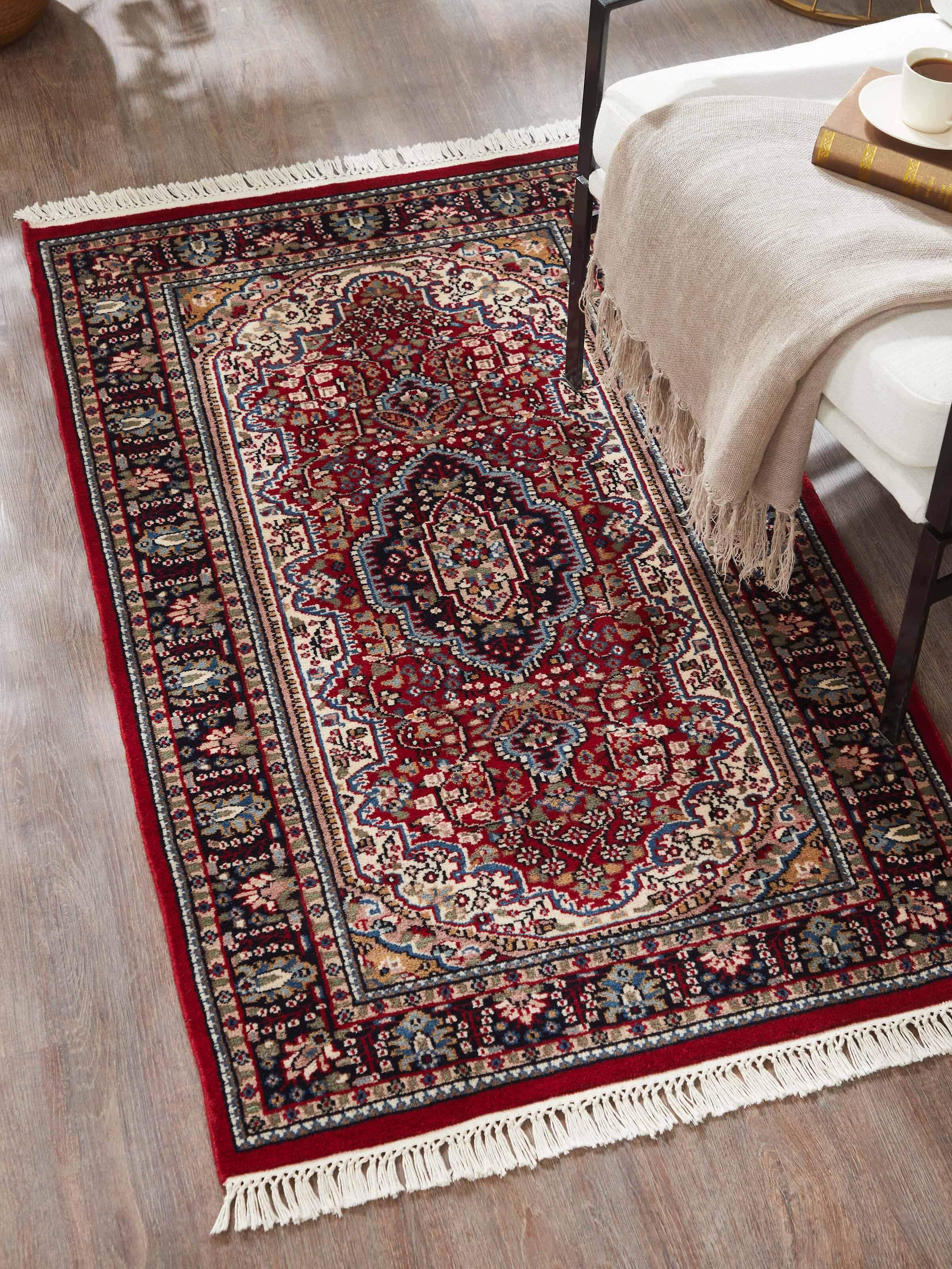 Lifestyle view of Persian red Oriental Gwalior wool hand-knotted carpet placed in a traditional living room setting.