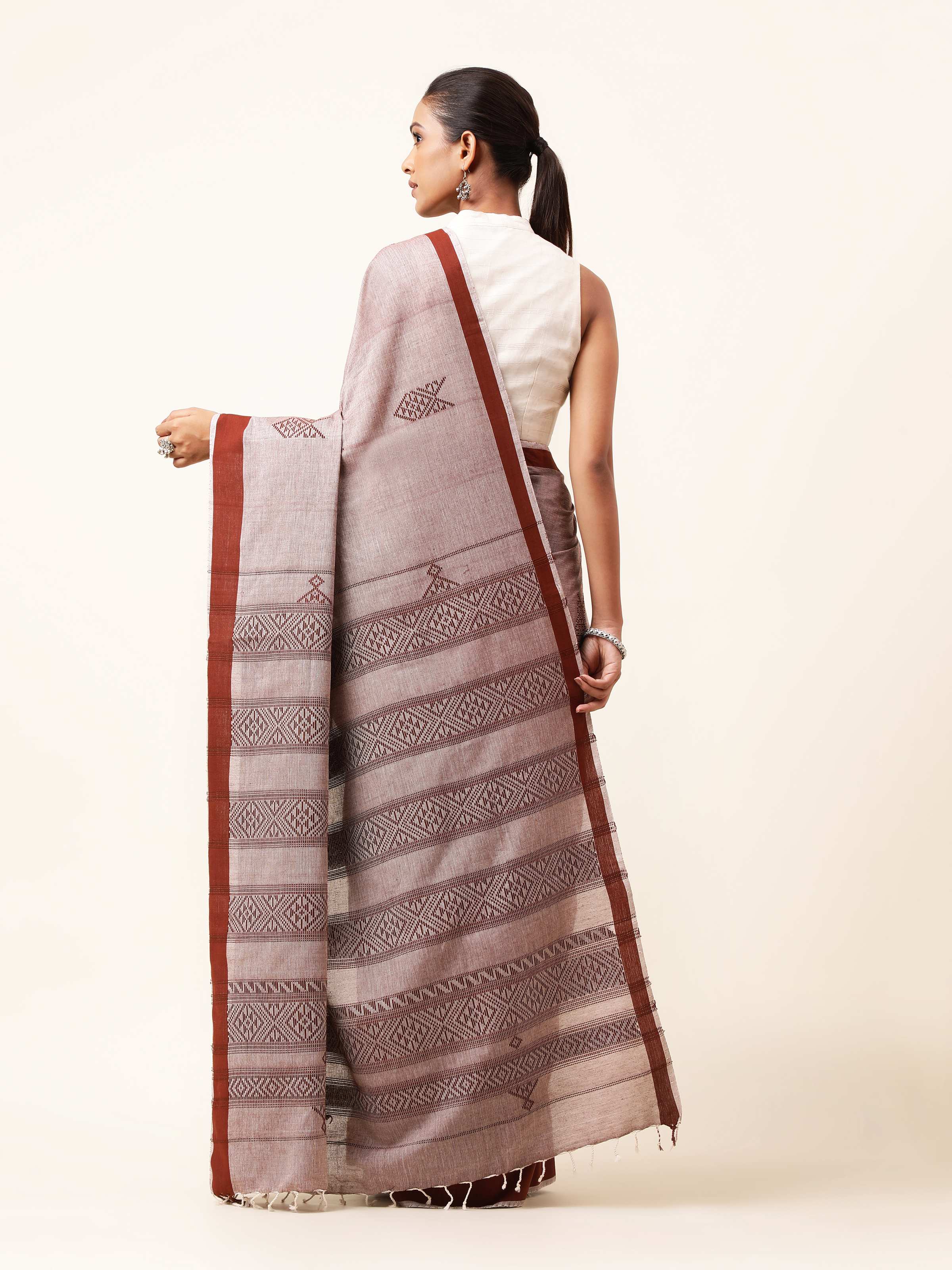 Back view of brown cotton extra-weft saree showcasing fall and border work