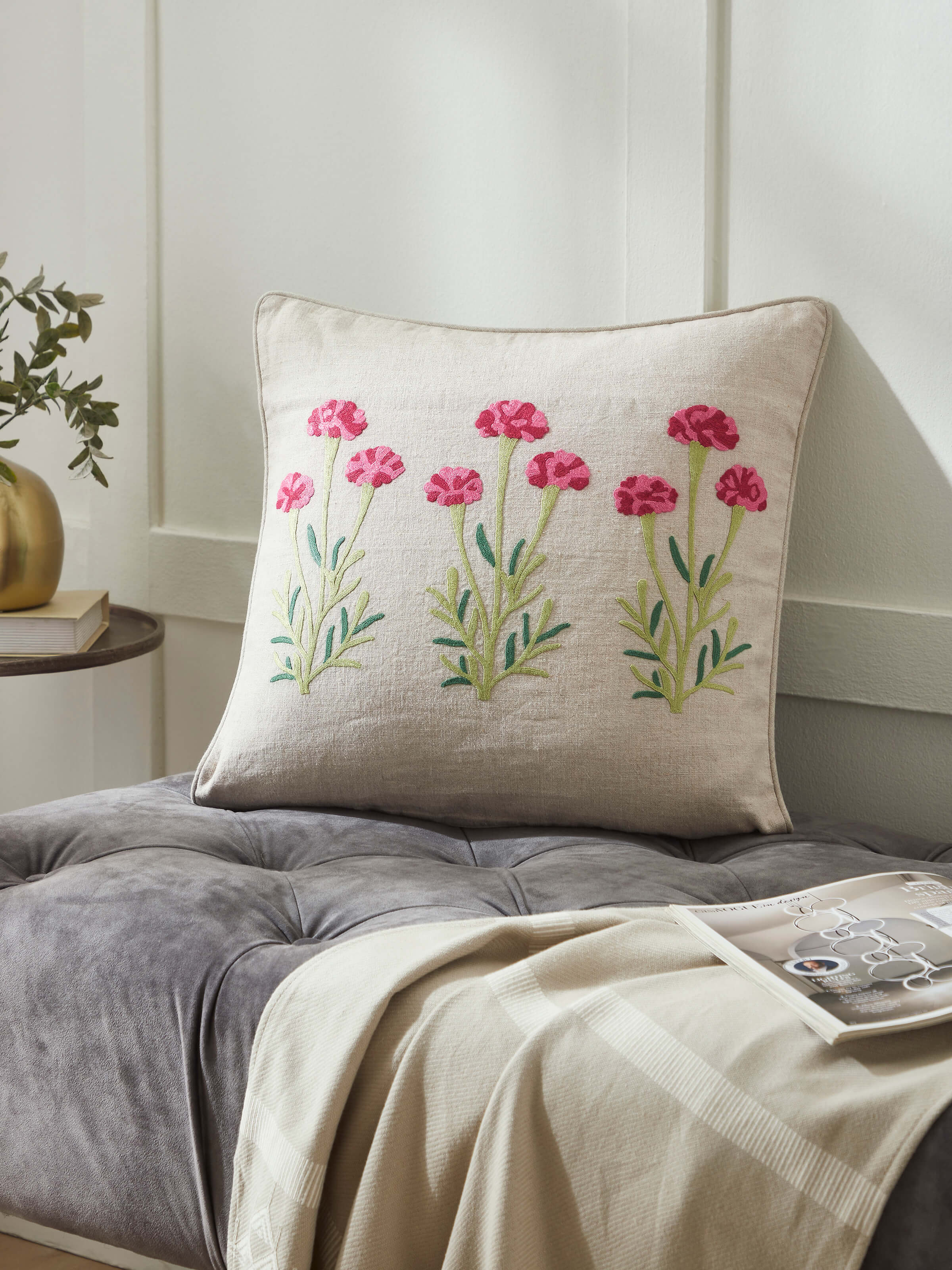 Lifestyle shot: Magenta embroidered cushion styled in a classic setting, highlighting Kashmiri craftsmanship.